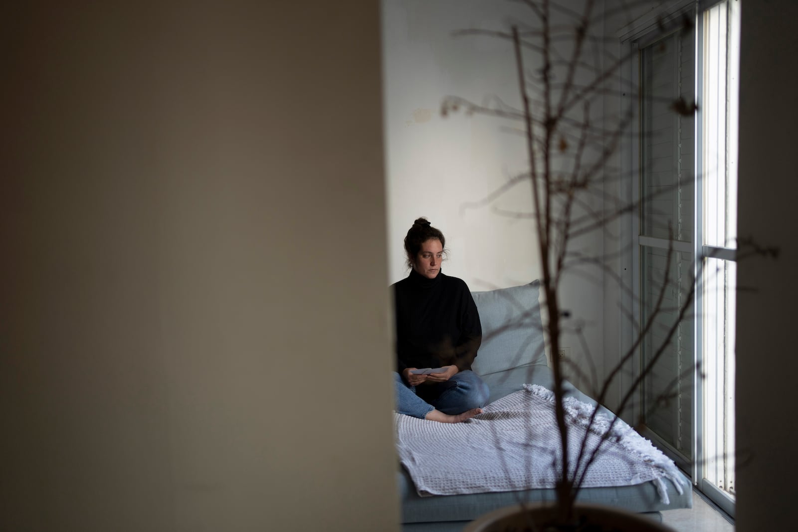 Yifat Zailer holds photos of her cousin, Sheri Bibas and Bibas' husband and sons who were taken hostage by Hamas militants, as she poses for a portrait at her home in Herziliyya, Israel, Wednesday, Jan. 15, 2025. (AP Photo/Maya Alleruzzo)