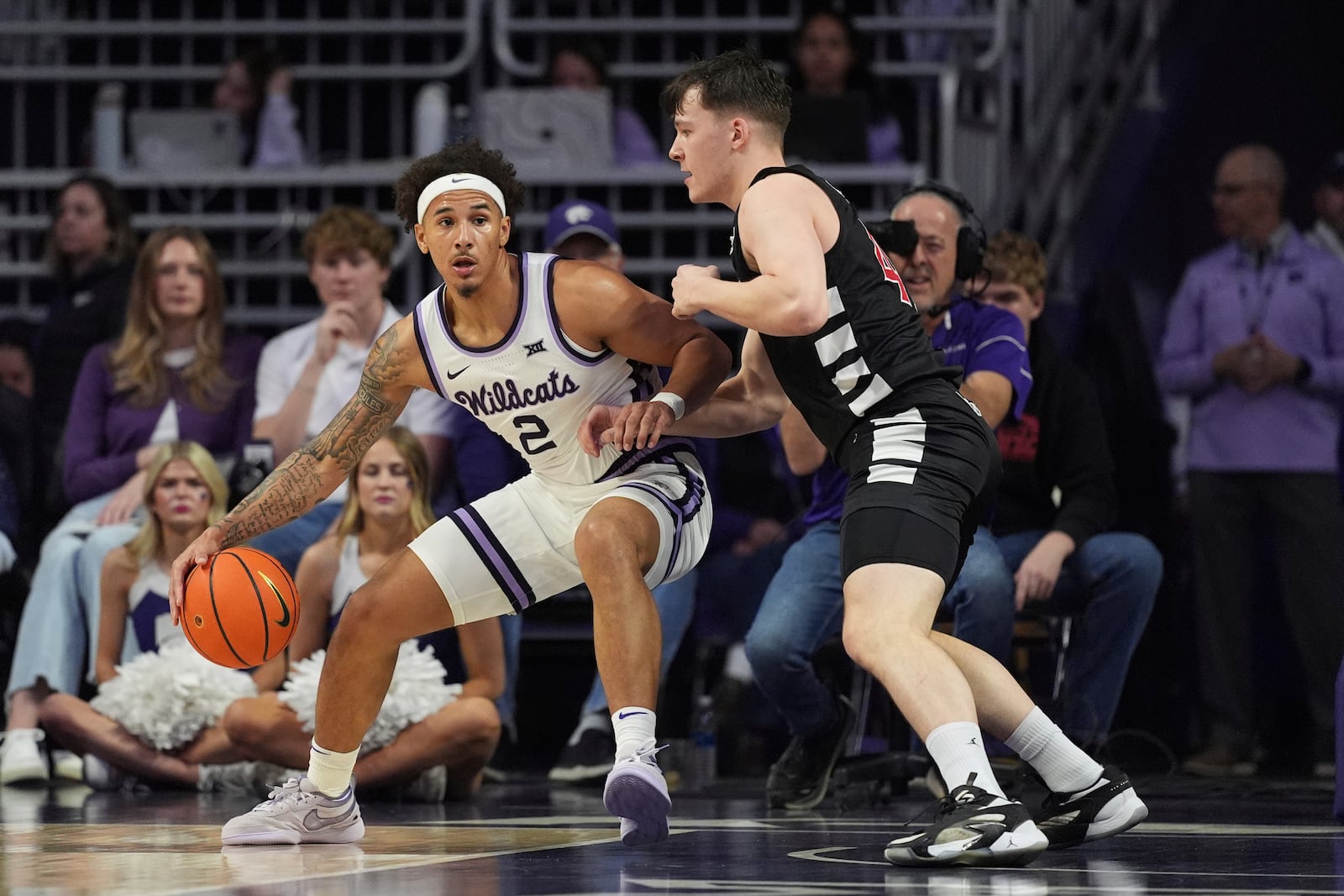 Kansas State guard Max Jones (2) tries to get past Cincinnati guard Simas Lukosius (41) during the first half of an NCAA college basketball game, Monday, Dec. 30, 2024, in Manhattan, Kan. (AP Photo/Charlie Riedel)