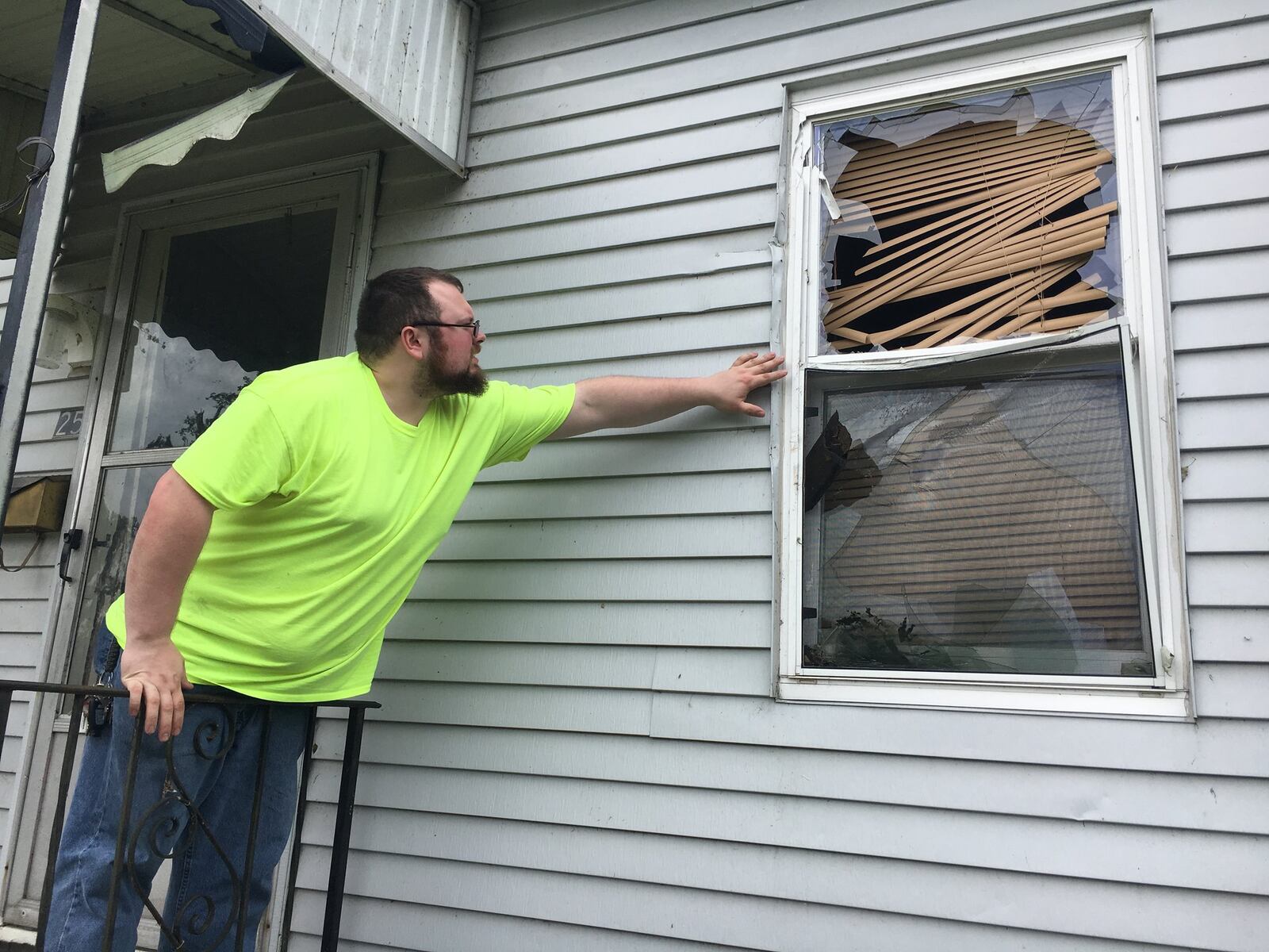 Michael Santana assesses damage to his home at the Overlook Houses in Riverside after a Memorial Day tornado threw a branch through his walls. STAFF PHOTO / HOLLY SHIVELY