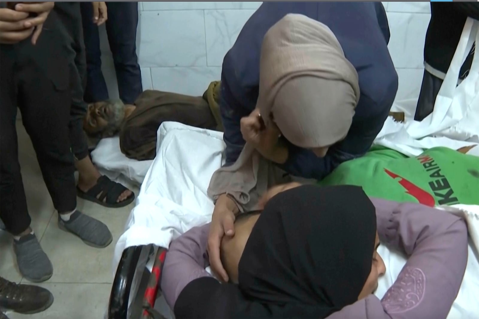 Two woman look over a body at Nasser hospital in Khan Younis after an Israeli airstrike on Saturday, Nov. 30, 2024. (AP Photo)