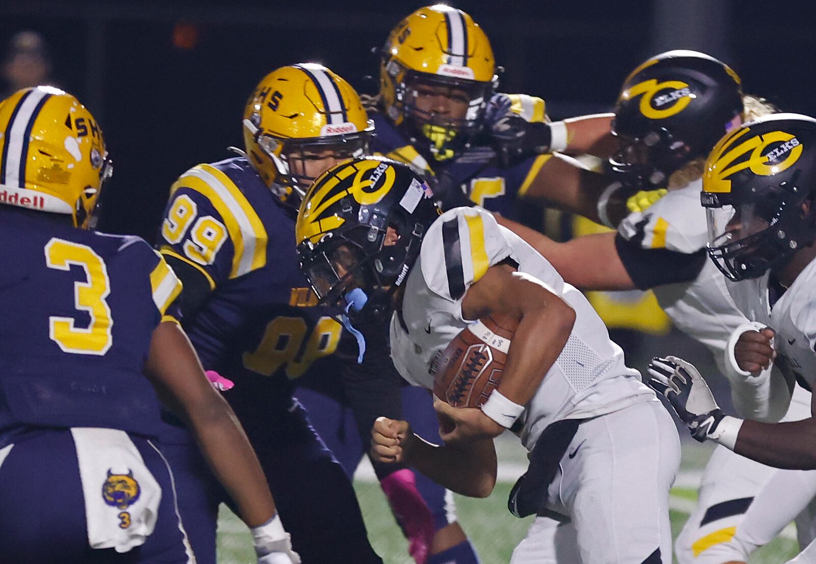 Centerville's Braylon Newcomb carries the ball through a pack of Springfield defenders during Friday's playoff game. BILL LACKEY/STAFF