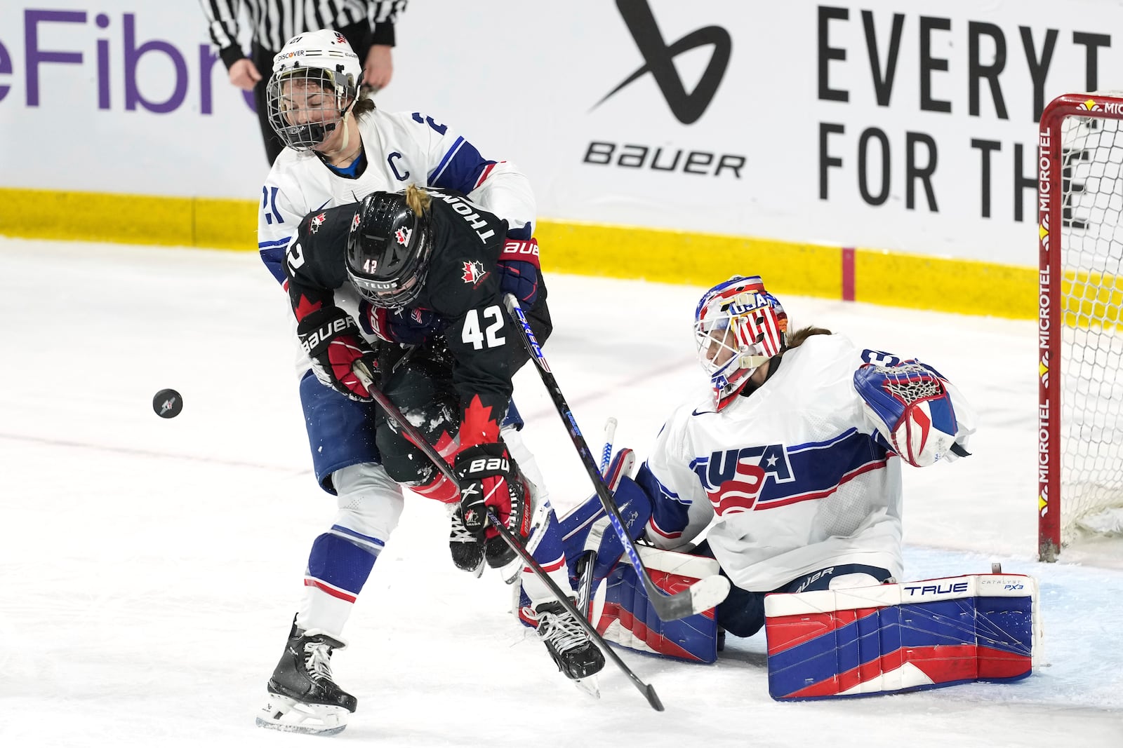 Team Canada's Claire Thompson, center, tries to jump out of the way of the puck while battling with Team USA's Hilary Knight, left, and goaltender Aerin Frankel during the first period of a Rivalry Series hockey game in Summerside, Prince Edward Island, Canada, Saturday, Feb. 8, 2025. (Darren Calabrese/The Canadian Press via AP)