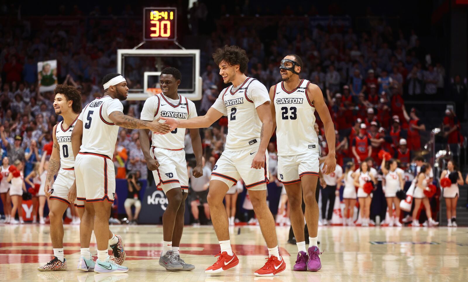 Dayton's Posh Alexander slaps hands with Nate Santos after a 3-pointer by Santos against New Mexico State on Wednesday, Nov. 20, 2024, at UD Arena. David Jablonski/Staff