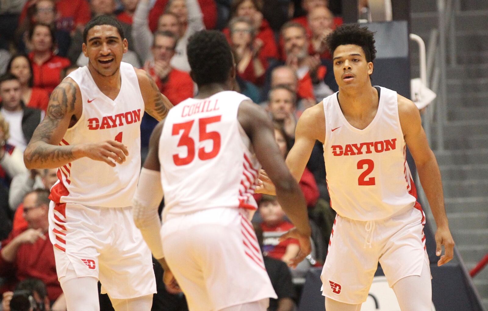 Dayton’s Obi Toppin, left, and Dwayne Cohill, center, celebrate after an assist by Frankie Policelli, right, against Mississippi State on Friday, Nov. 30, 2018, at UD Arena.