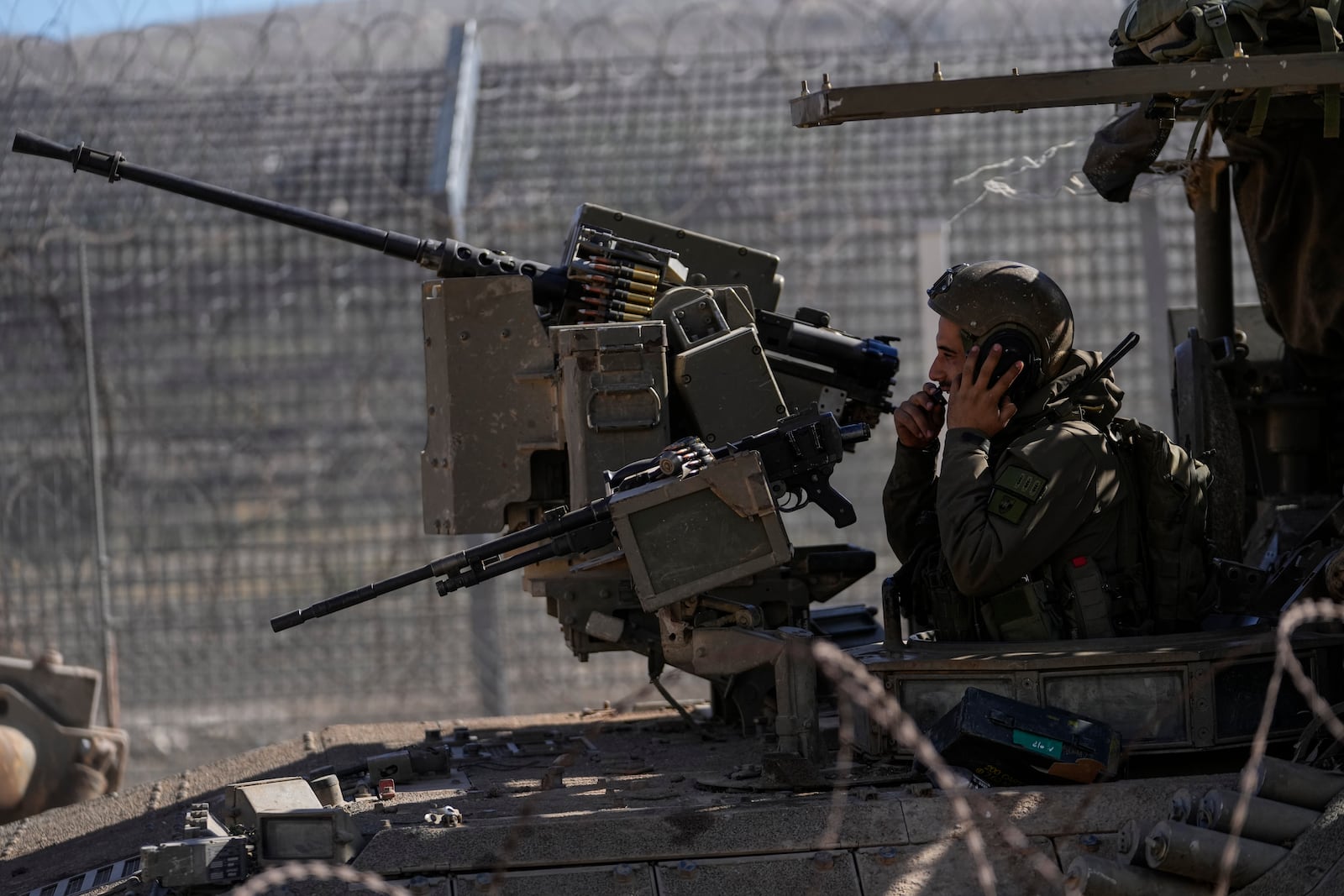 An Israeli soldier stands on the top of an armoured vehicle before crossing the security fence, moving towards the so-called Alpha Line that separates the Israeli-controlled Golan Heights from Syria, in the town of Majdal Shams, Friday, Dec. 13, 2024. (AP Photo/Matias Delacroix)