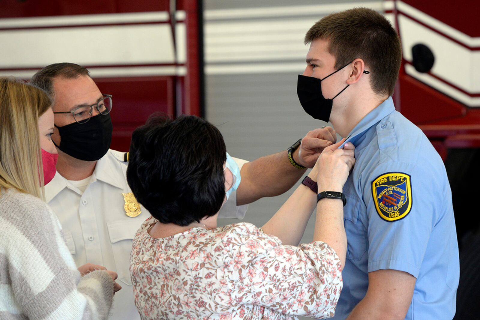 Ryan Hartmann (right), a new Air Force firefighter with the 788th Civil Engineer Squadron, is pinned on by his mother, Vicki, and Fire Chief Jacob King during a promotion ceremony on March 29 at Wright-Patterson Air Force Base. U.S. AIR FORCE PHOTO/TY GREENLEES