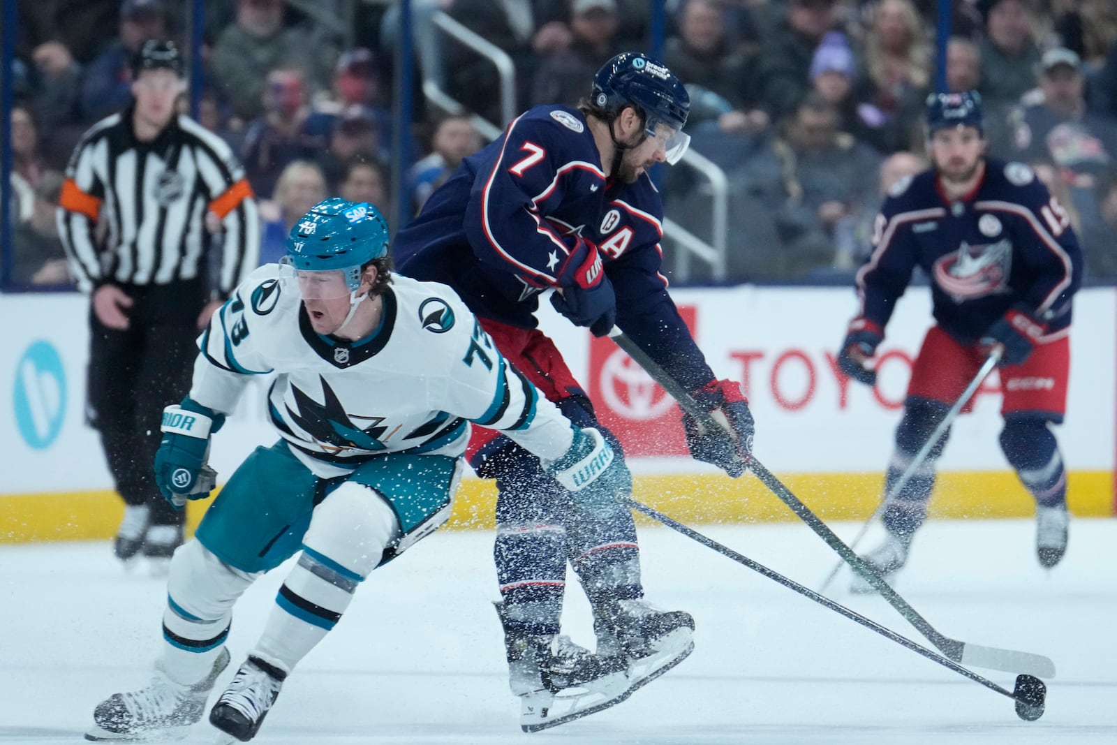 San Jose Sharks center Tyler Toffoli (73) checks Columbus Blue Jackets center Sean Kuraly (7) in the second period of an NHL hockey game Thursday, Jan. 16, 2025, in Columbus, Ohio. (AP Photo/Sue Ogrocki)