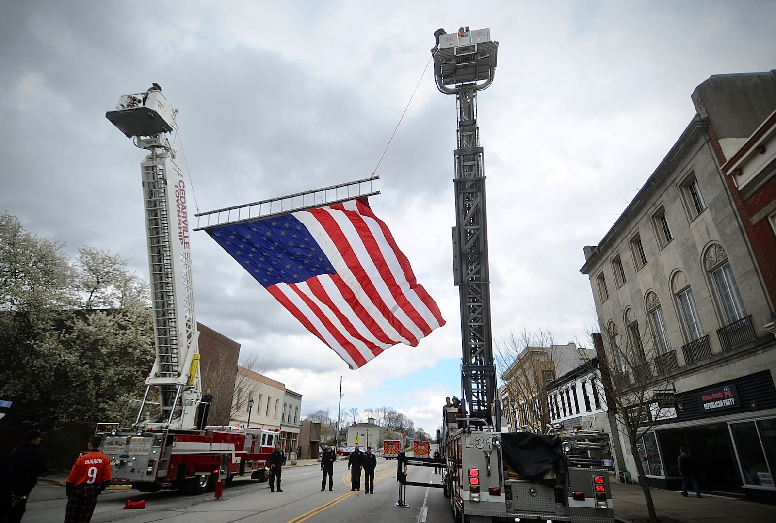 Xenia and Cedarville fire departments fly a large American flag Wednesday, April 3, 2024, on Main Street in Xenia for the ceremony "50 Years Later: Remembering the Xenia Tornado." MARSHALL GORBY\STAFF