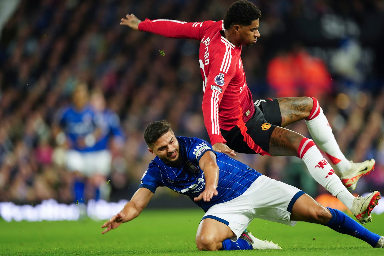 Ipswich Town's Sam Morsy, bottom, tackles Manchester United's Marcus Rashford during the English Premier League soccer match between Ipswich Town and Manchester United at Portman Road stadium in Ipswich, England, Sunday, Nov. 24, 2024. (AP Photo/Dave Shopland)