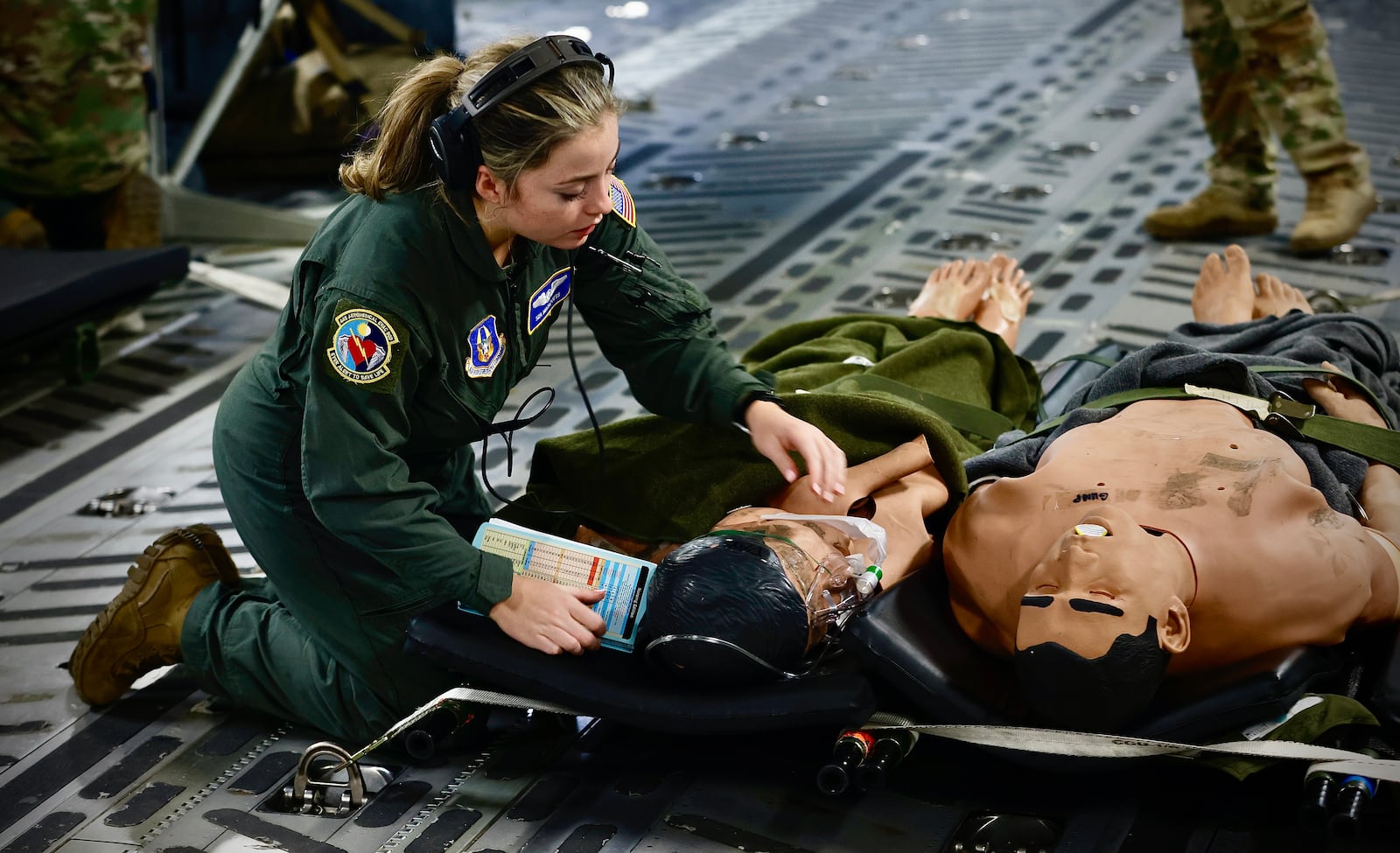 Senior Airman, Madilynn Potts, Flight Medic, demonstrates the care injured people would receive during a mock evacuation drill at Wright Patterson Air Force base Wednesday, October 16, 2024 on a C-17 Globemaster lll. MARSHALL GORBY\STAFF