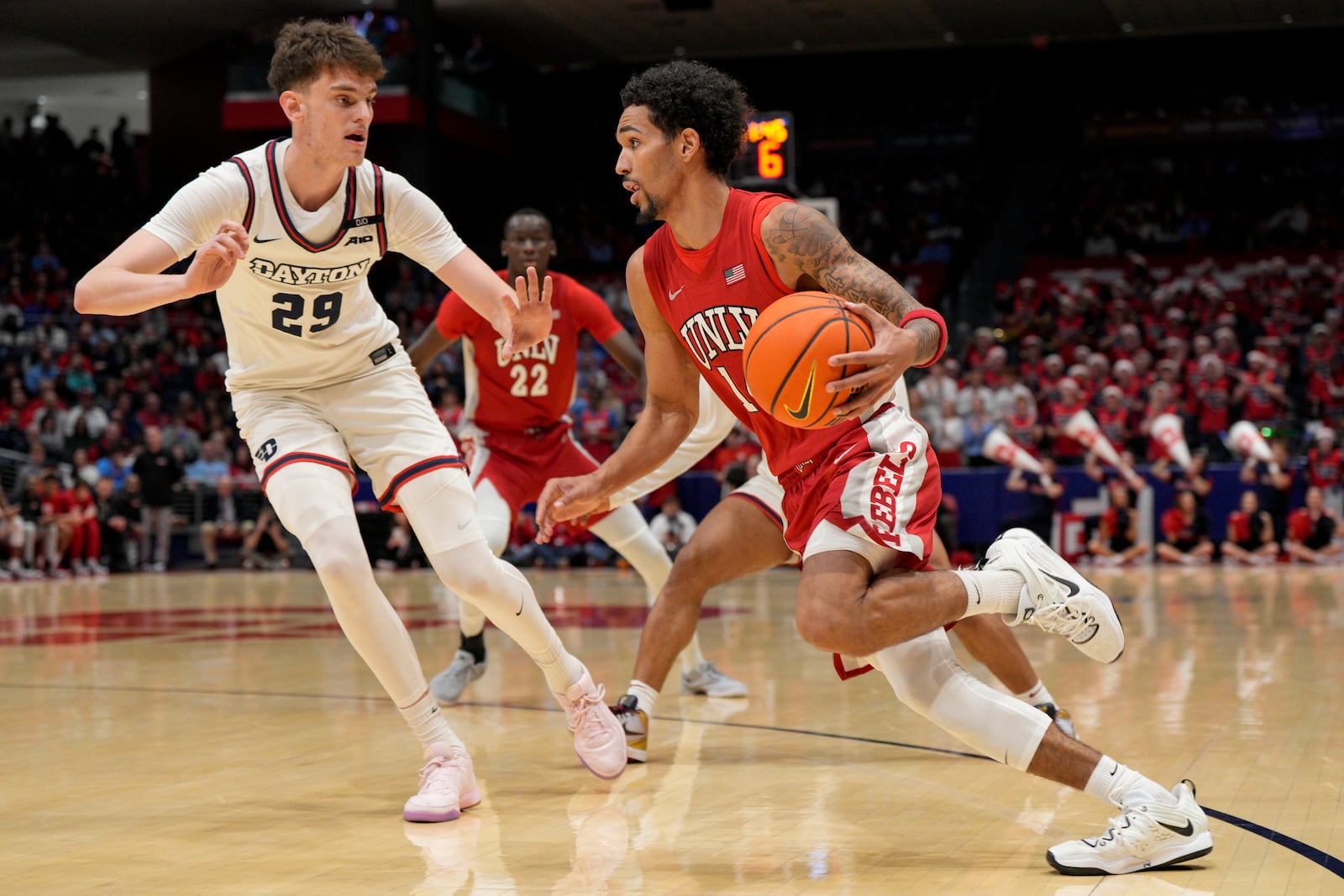 UNLV guard Jailen Bedford, center right, dribbles against Dayton forward Amael L'Etang (29) during the first half of an NCAA college basketball game, Tuesday, Dec. 17, 2024, in Dayton, Ohio. (AP Photo/Jeff Dean)