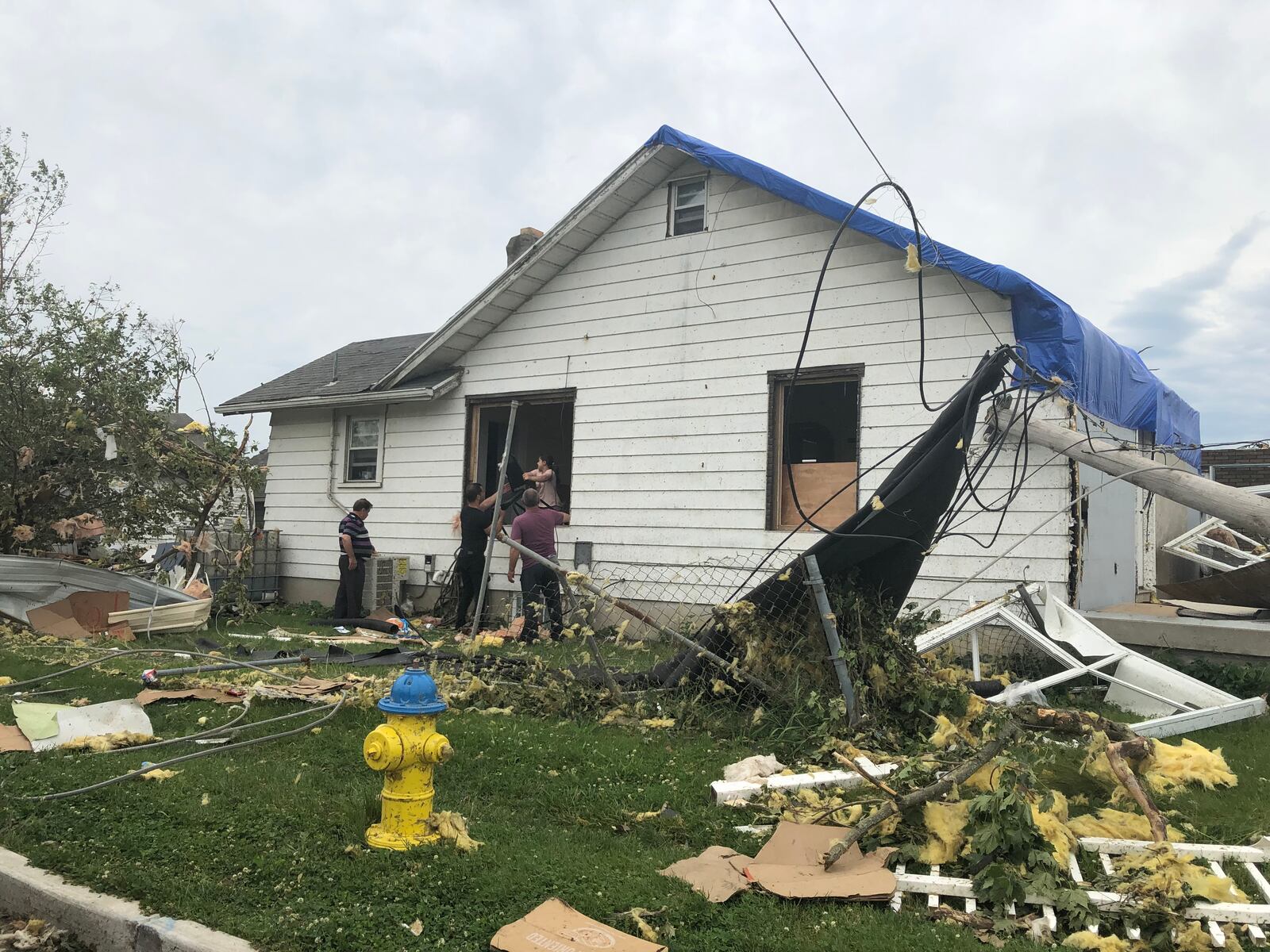 Residents who live on Troy Street in Old North Dayton hand furniture through a torn out window. CORNELIUS FROLIK / STAFF