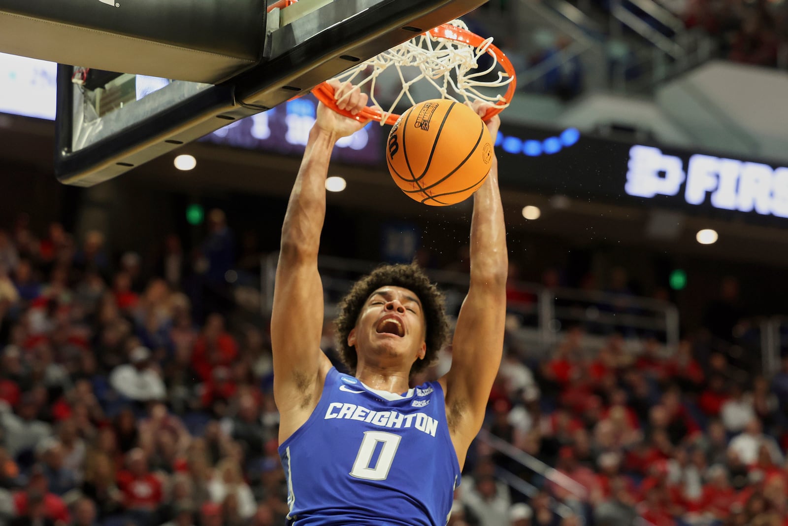 Creighton's Jasen Green (0) dunks during the second half against Louisville in the first round of the NCAA college basketball tournament in Lexington, Ky., Thursday, March 20, 2022. (AP Photo/James Crisp)