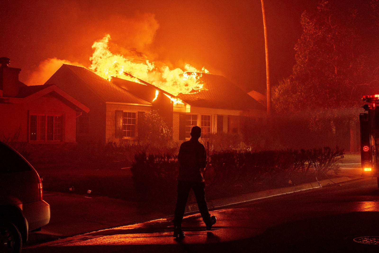 FILE - A firefighter walks toward a burning structure as the Eaton Fire advances Tuesday, Jan. 7, 2025 in Altadena, Calif. (AP Photo/Ethan Swope, File)