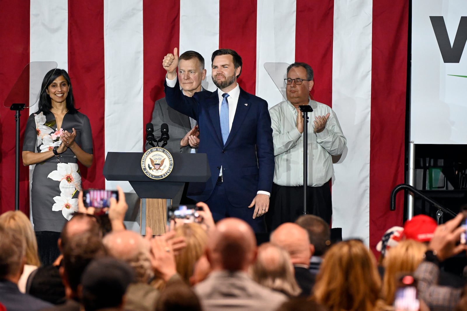 Vice President JD Vance, standing foreground, gives a thumbs up following a rally where he spoke about "America's industrial resurgence," Friday, March 14, 2025, at Vantage Plastics in Bay City, Mich. (AP Photo/Jose Juarez)