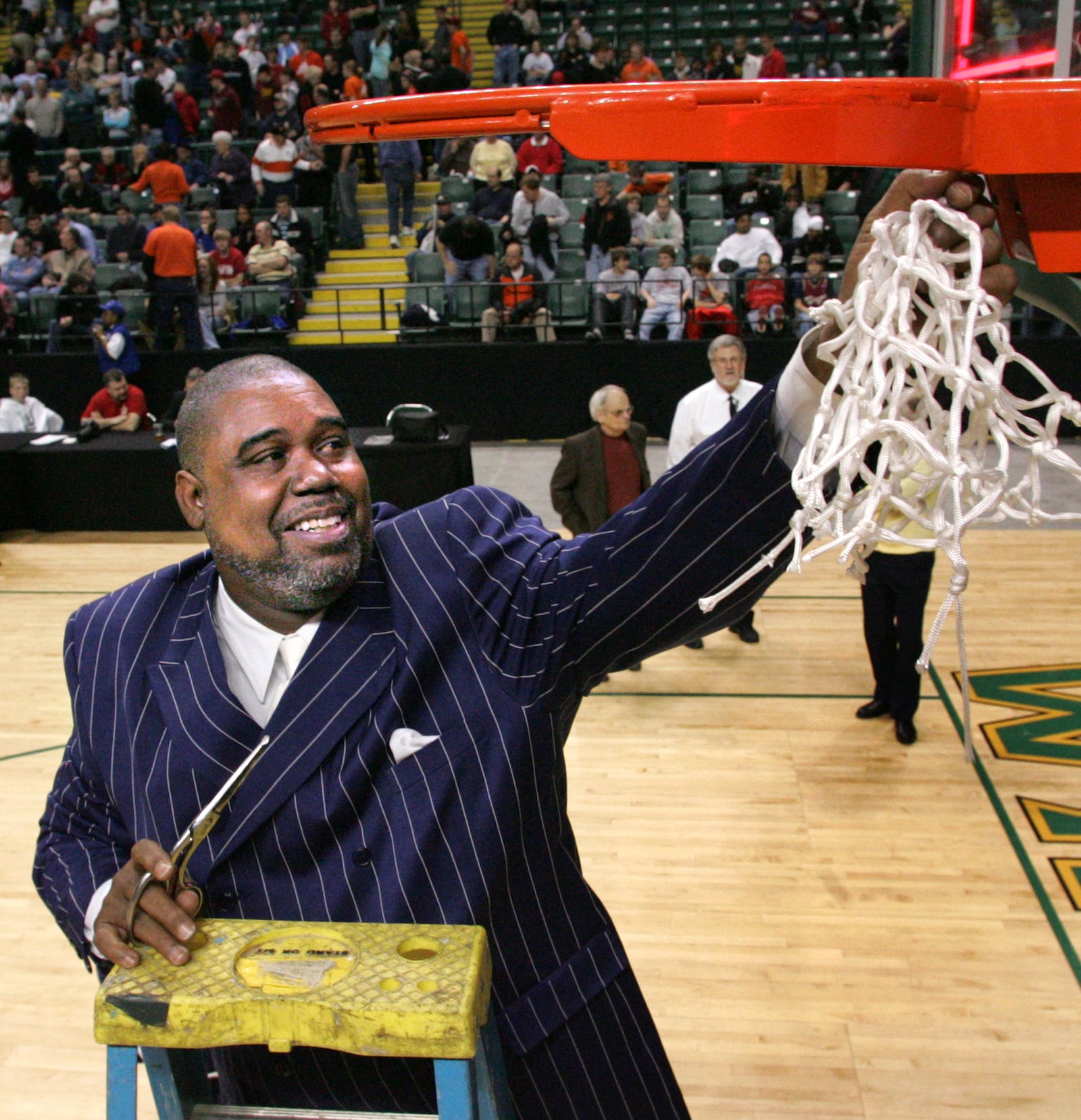 Peter Pullen, the Dunbar boys basketball coach, cuts down the net as in celebration of winning a Division II regional title in 2006. DDN FILE