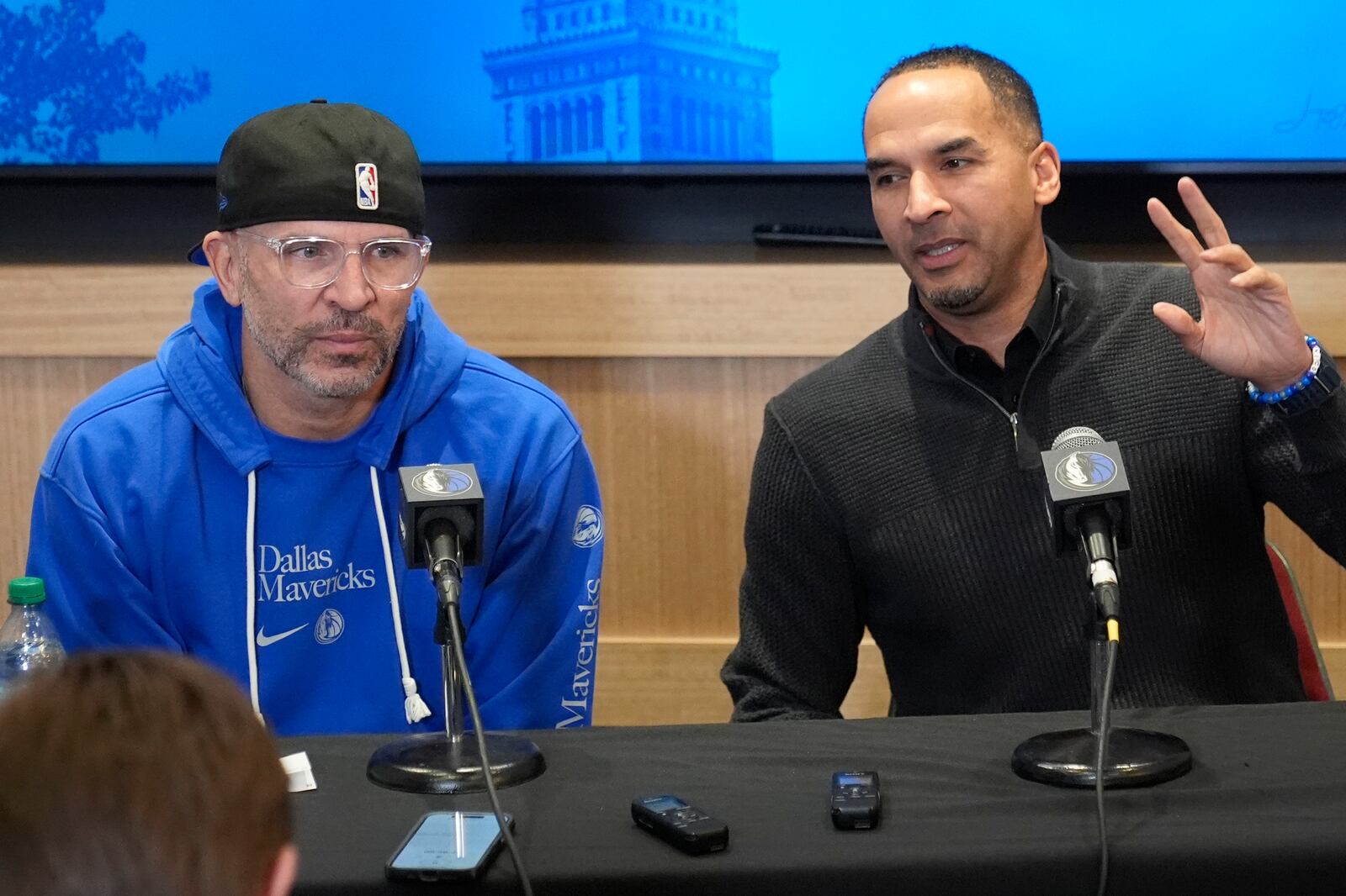 Dallas Mavericks head coach Jason Kidd, left, and general manager Nico Harrison, right, discuss the trade of Luka Doncic before an NBA basketball game against the Cleveland Cavaliers, Sunday, Feb. 2, 2025, in Cleveland. (AP Photo/Sue Ogrocki)