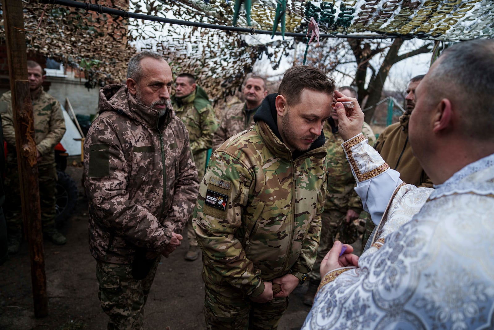 Military chaplain Yurii of 24th Mechanized Brigade blesses Ukrainian servicemen during Christmas near the frontline town of Chasiv Yar, Donetsk region, Ukraine, Wednesday Dec. 25, 2024. (AP Photo/Evgeniy Maloletka)