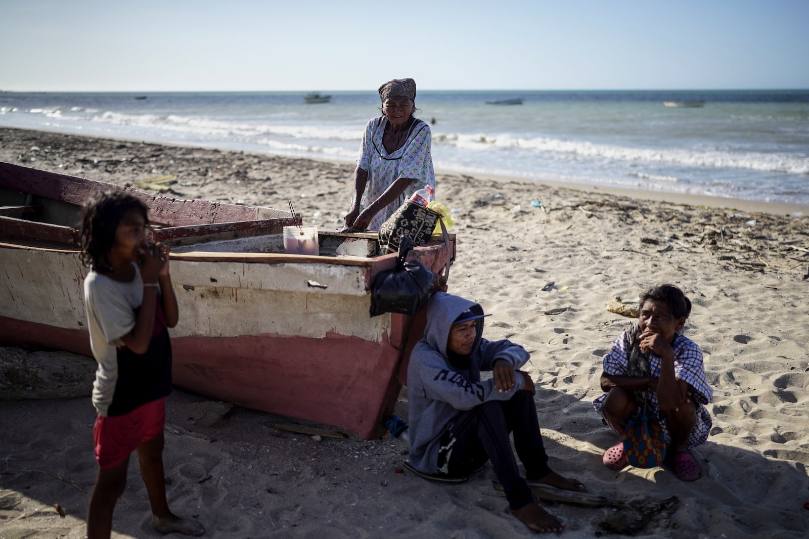 A family of fishers, of the Wayuu Indigenous group, meet on the beach, in Manaure, Colombia, Thursday, Feb. 6, 2025. (AP Photo/Ivan Valencia)