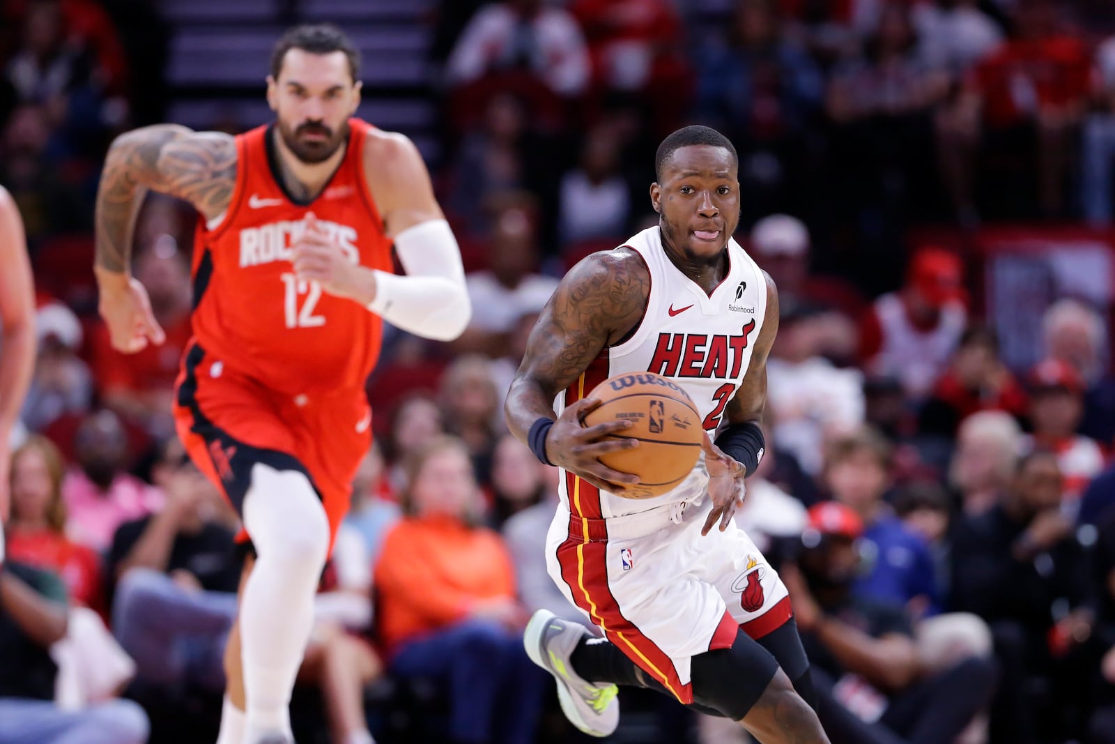 Miami Heat guard Terry Rozier III, right, drives down court in front of Houston Rockets center Steven Adams (12) during the first half of an NBA basketball game Sunday, Dec. 29, 2024, in Houston. (AP Photo/Michael Wyke)