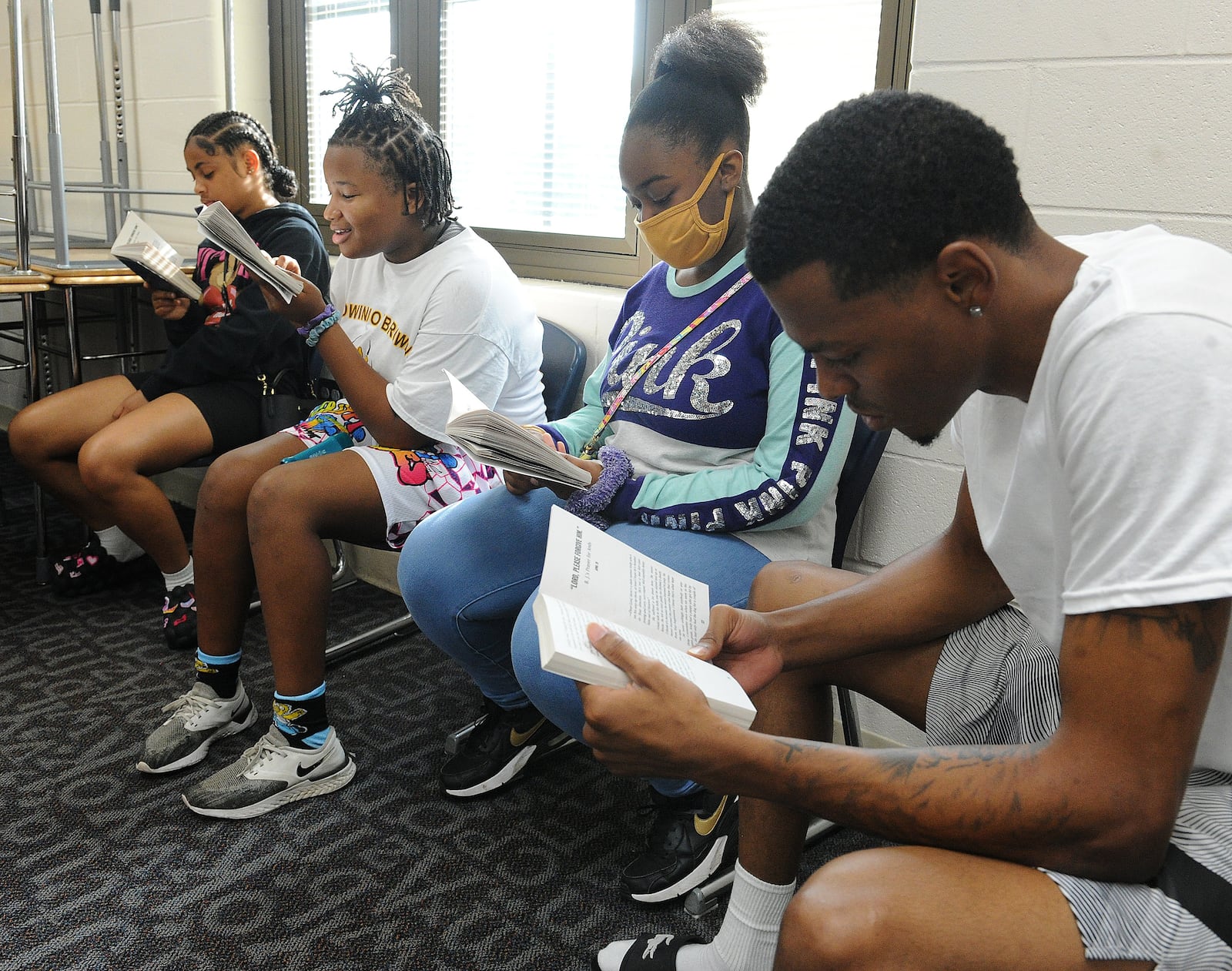 Students, from left, Jordan Jamerson, LaVonna Whatley and Shayla Davis, read with Servant Leader Intern, Terry Matthews III, during a DPS Summer Camp at Edwin Joel Brown Middle School. MARSHALL GORBY\STAFF