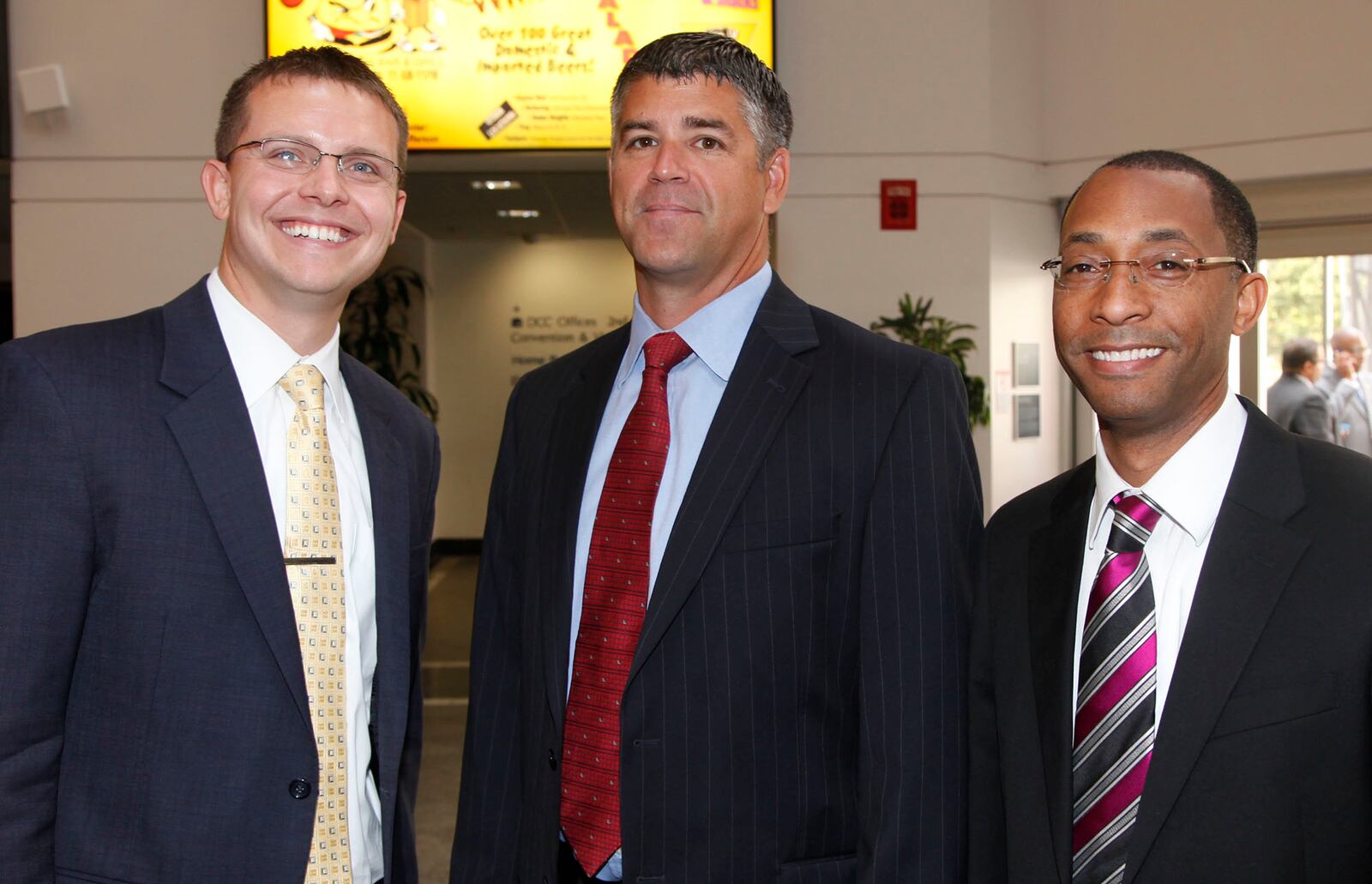 Dave Harper, center, stands with Matt Farrell, of NCAA First Four Committee, and Troy Washington at a Dayton Presidents’ Club Citizen Legion of Honor Award Luncheon in 2014. TY GREENLEES/STAFF