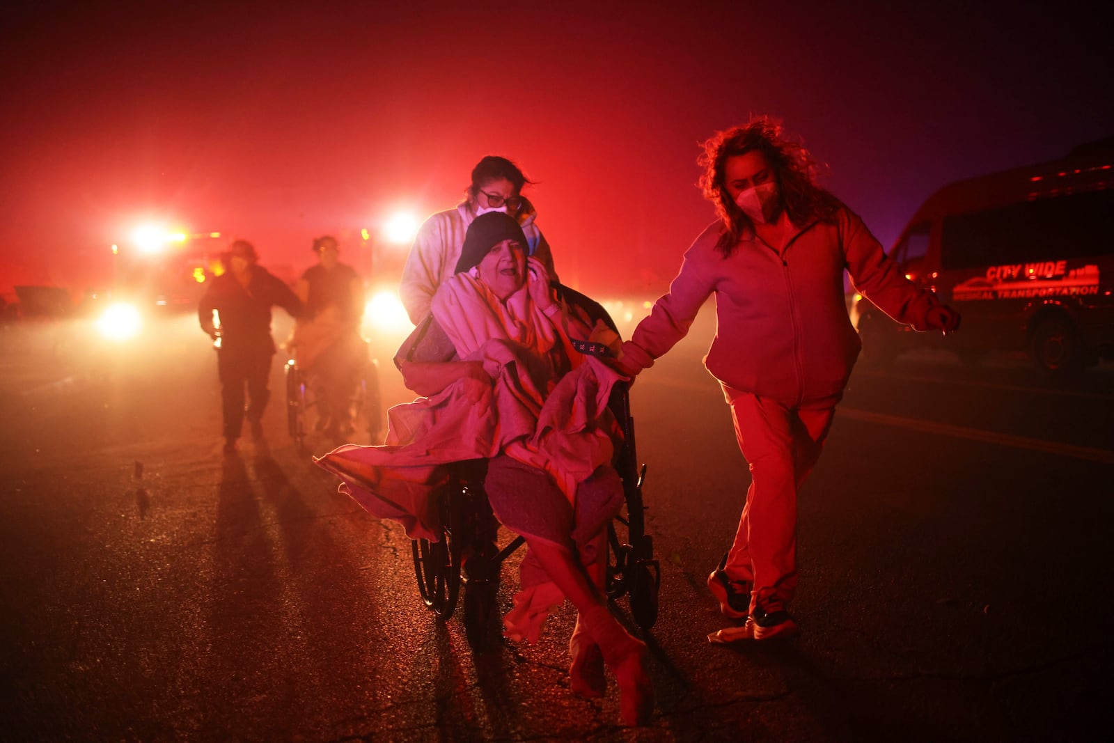 FILE - Residents and staff at Pasadena Park Healthcare & Wellness Center evacuate as the Eaton Fire approaches on Jan. 7, 2025, in Altadena, Calif. (AP Photo/Ethan Swope, File)