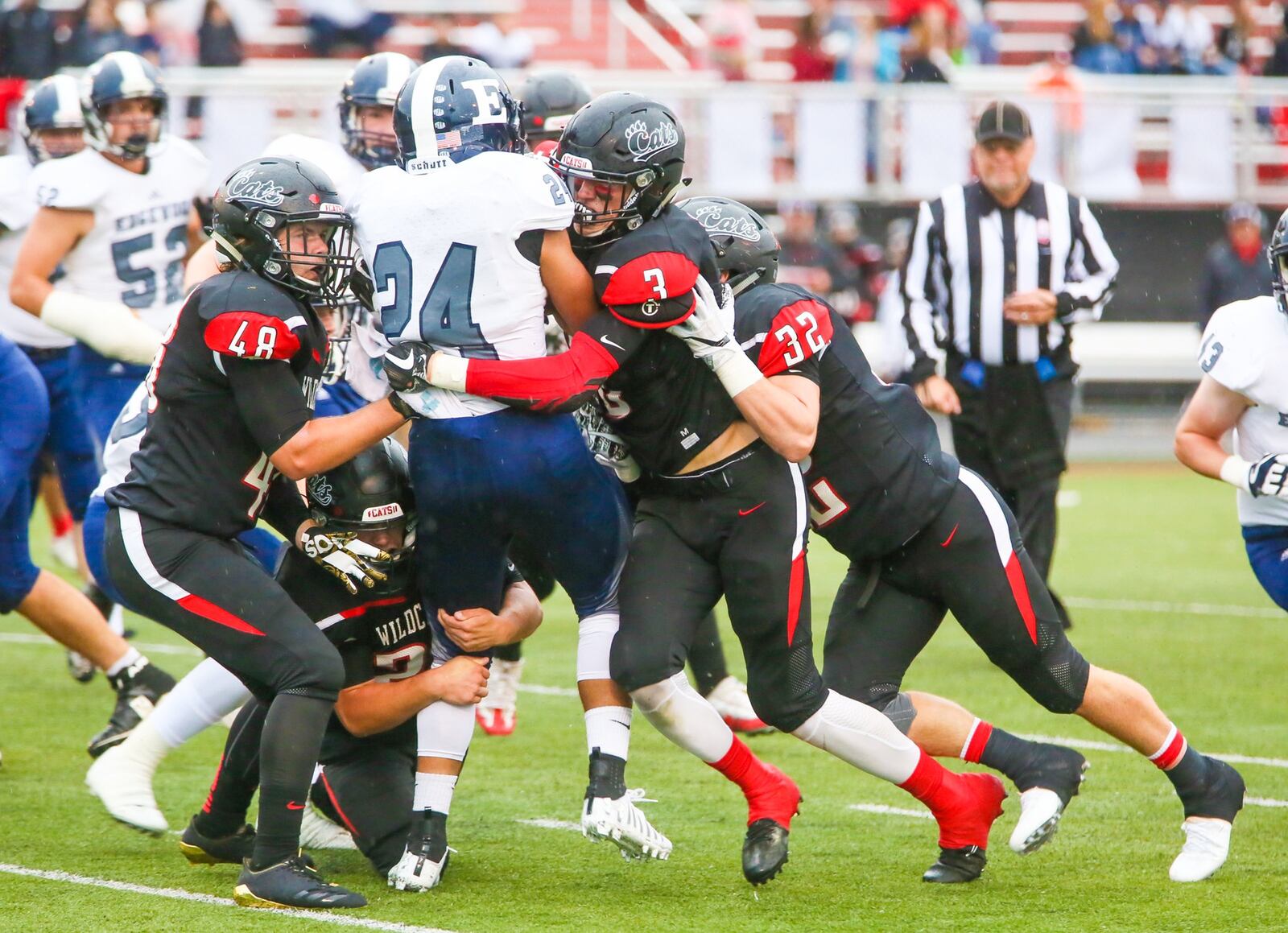 Edgewood running back Elijah Williams (24) is stood up by the Franklin defense, including Logan Clark (48), Kyle Rickard (3) and Matt Centers (32), during Friday night’s game at Atrium Stadium in Franklin. GREG LYNCH/STAFF