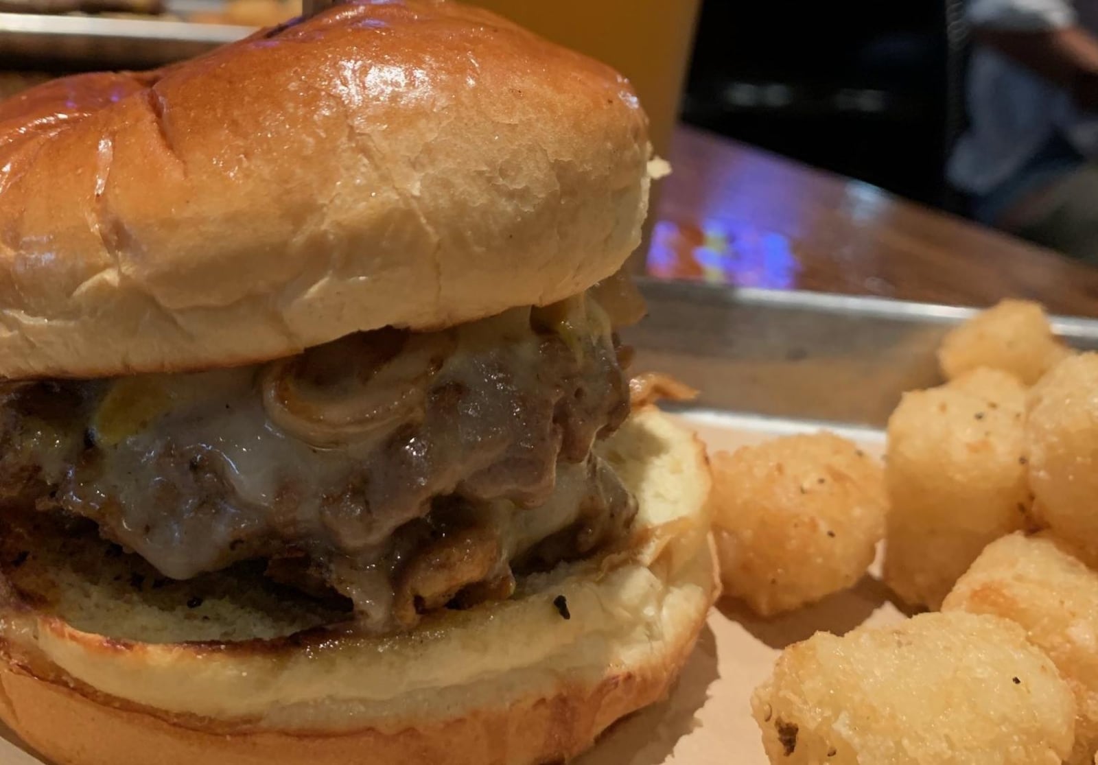 The Six Napkins burger at Bar Louie at the Greene made with two Impossible Burger patties, smashed, grilled with yellow mustard, topped with caramelized onions, double white cheddar, pickles and Louie sauce. Contributed photo by Alexis Larsen