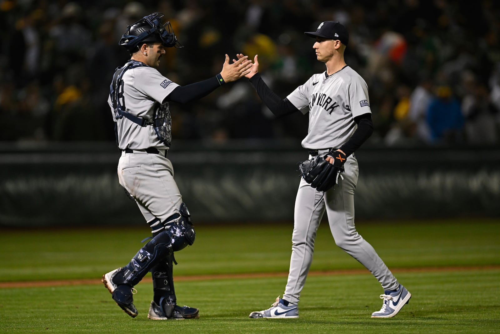 New York Yankees pitcher Luke Weaver (right) celebrates with catcher Austin Wells (left) after winning a baseball game against the Oakland Athletics Friday, Sept. 20, 2024, in Oakland, Calif. (AP Photo/Eakin Howard)