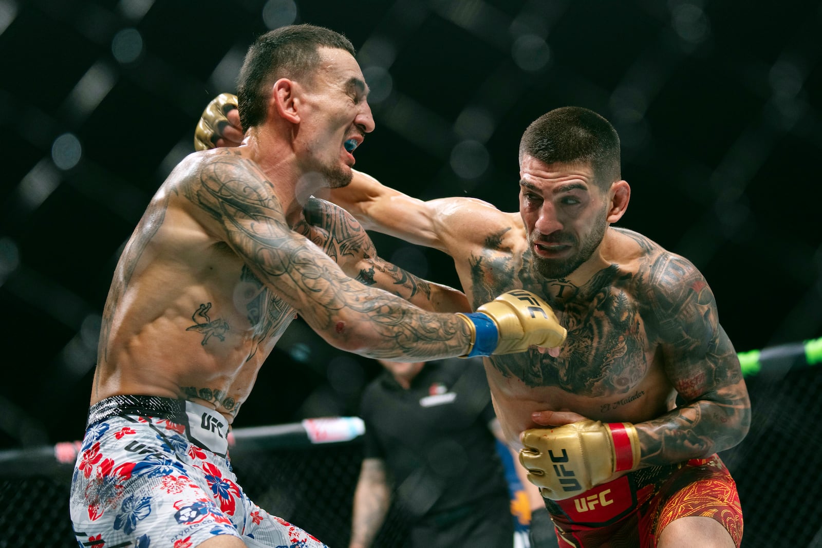 Champion Ilia Topuria, right, battles Max Holloway during a mixed martial arts featherweight title bout at UFC Fight Night on Saturday, Oct. 26, 2024, in Abu Dhabi, United Arab Emirates. (AP Photo/Altaf Qadri)