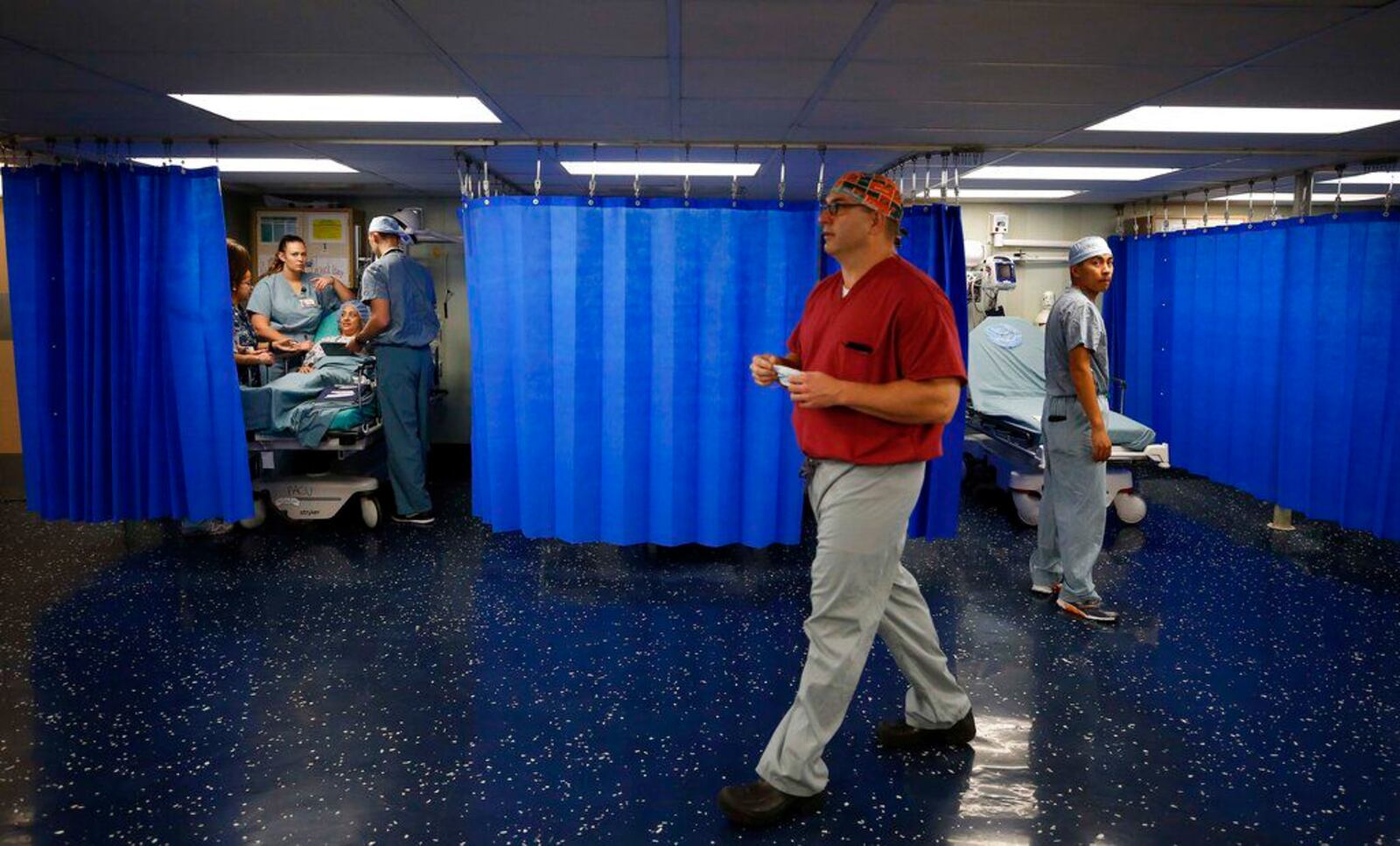 In this Nov. 27, 2018 file photo, a doctor from the USNS Comfort hospital ship walks past patients, in Riohacha, Colombia. On Wednesday, March, 18, 2020, President Donald Trump announced he will dispatch the Comfort to the New York City Harbor to provide New York City hospitals with relieve in taking on the COVID-19 virus.