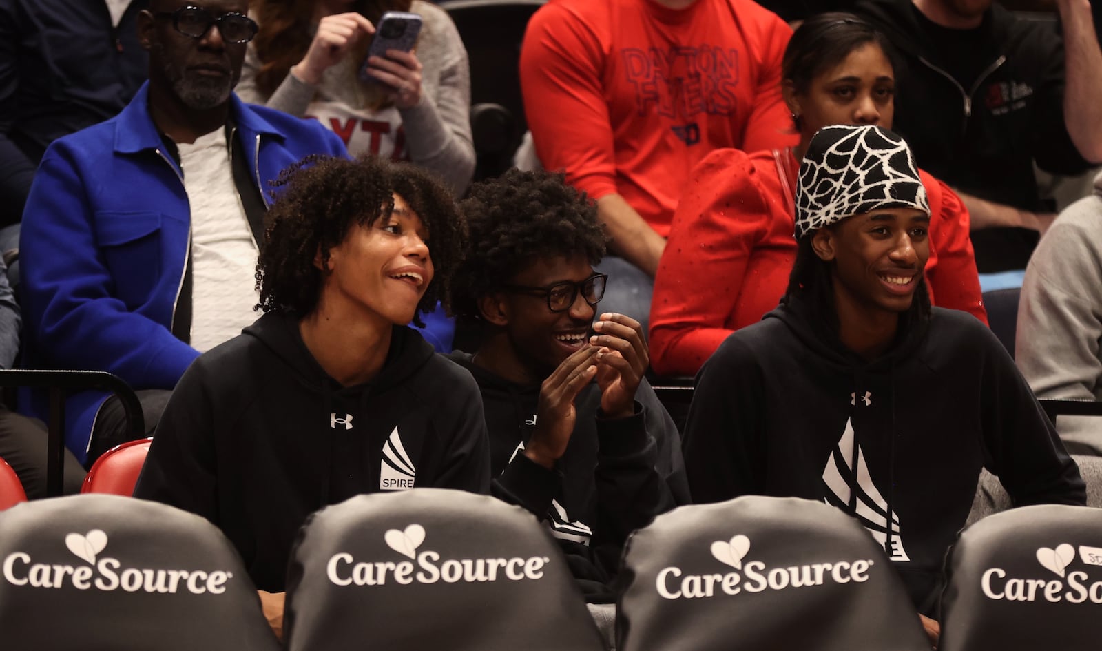 Three recruits from Spire Academy (left to right: Jackson Williams, Jayon Alexander and Collin Ross) watch from behind the bench as Dayton plays New Mexico State on Wednesday, Nov. 20, 2024, at UD Arena. David Jablonski/Staff