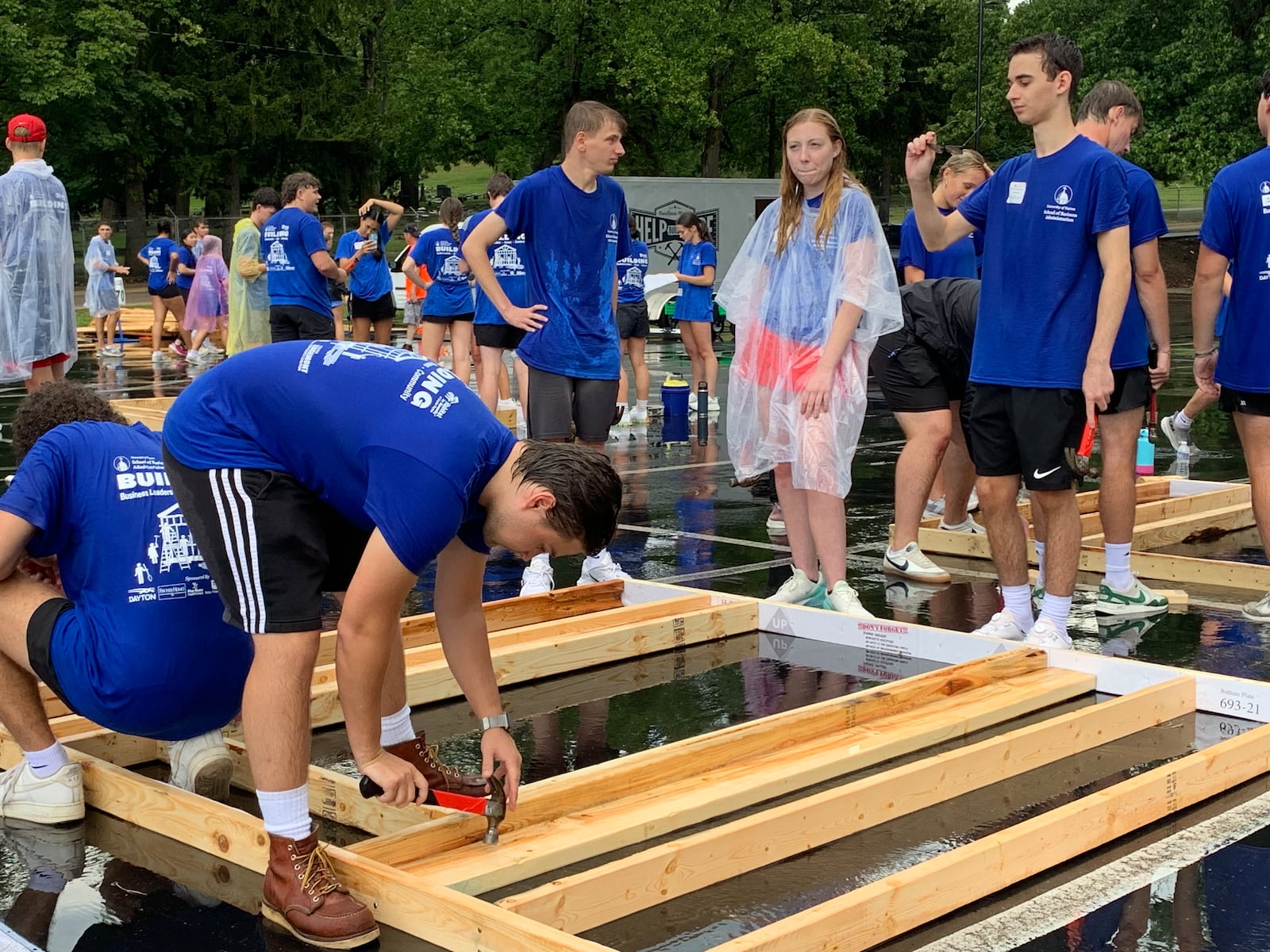 More than 400 University of Dayton students braved pouring rain Sunday to build wood frame walls for Dayton Habitat for Humanity. LONDON BISHOP/STAFF