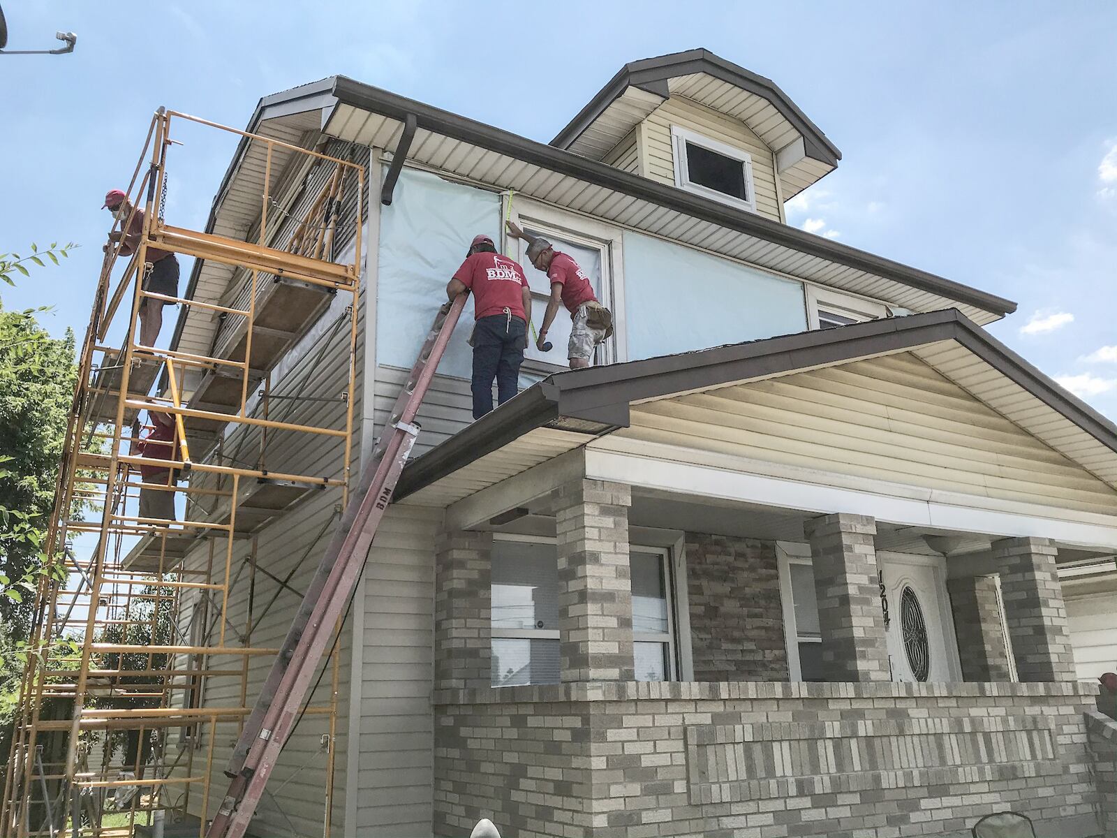 Southern Ohio District Brethren Disaster Ministries volunteers replace siding on a house on Valley Street in Dayton that was damaged by a 2019 Memorial Day tornado. The Church of the Brethren has 40 churches in southwestern Ohio and volunteers plan to work in the Dayton area into autumn. JIM NOELKER/ STAFF