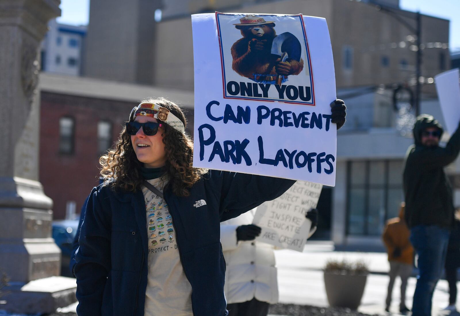 Rachael Stark holds up a sign at a "Save Steamtown" rally to protest the Trump administration layoffs at the Steamtown National Historic Site in Scranton, Pa., Saturday, Feb. 22, 2025. (Aimee Dilger/WVIA via AP)