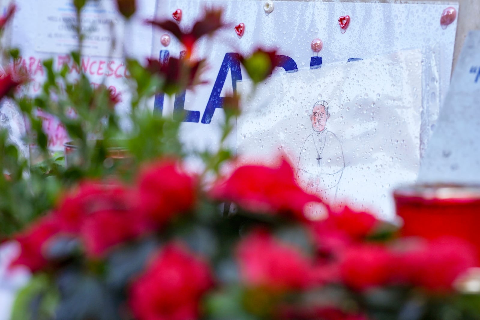 Candles and flowers for Pope Francis are seen at the Agostino Gemelli Polyclinic, in Rome, Wednesday, Feb. 26, 2025, where the Pontiff is hospitalized since Friday, Feb. 14. (AP Photo/Andrew Medichini)