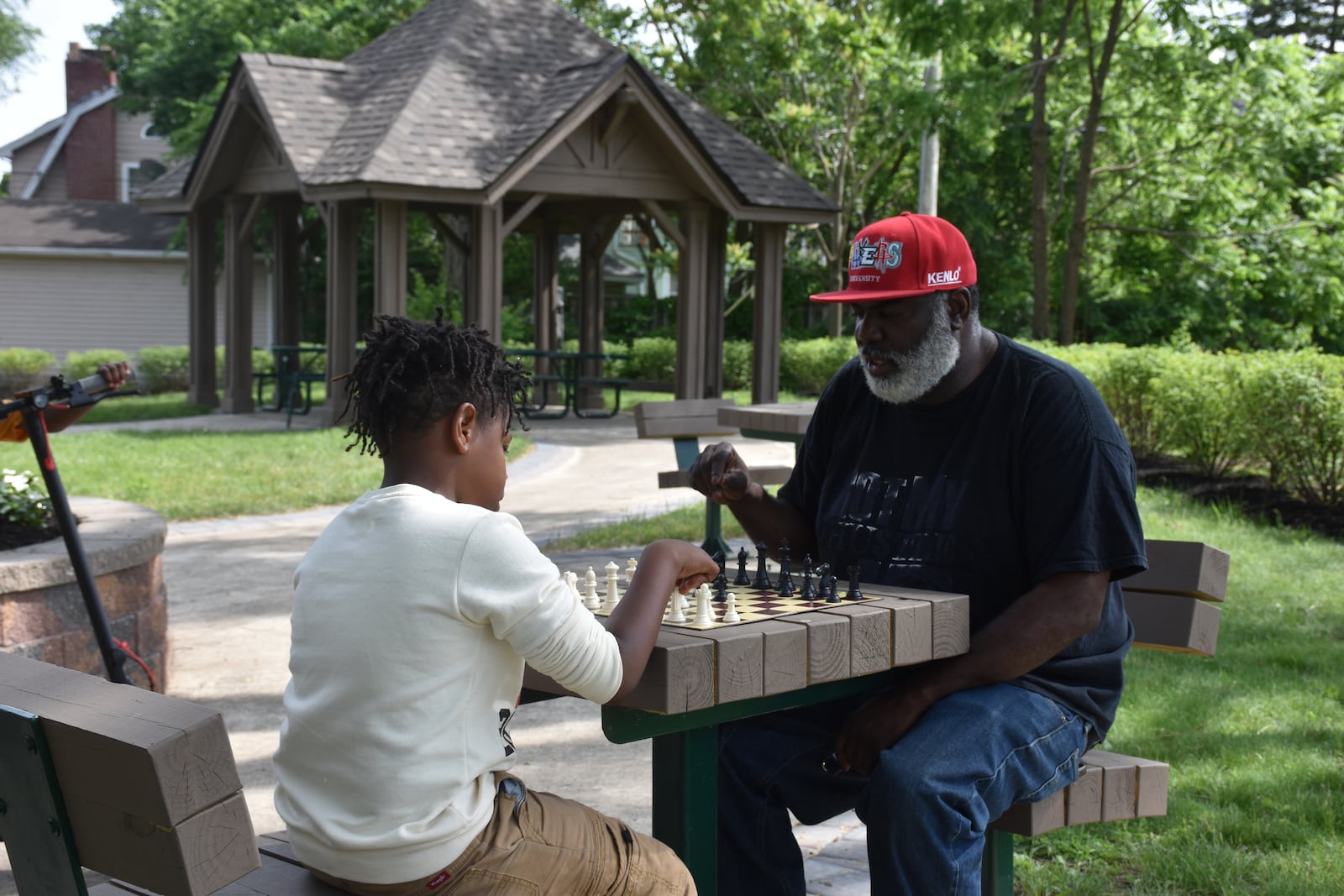 Iran Johnson, 51, plays chess with a boy at Carrick's Corner Pocket Park, located at 300 Delaware Ave. in northwest Dayton. CORNELIUS FROLIK / STAFF