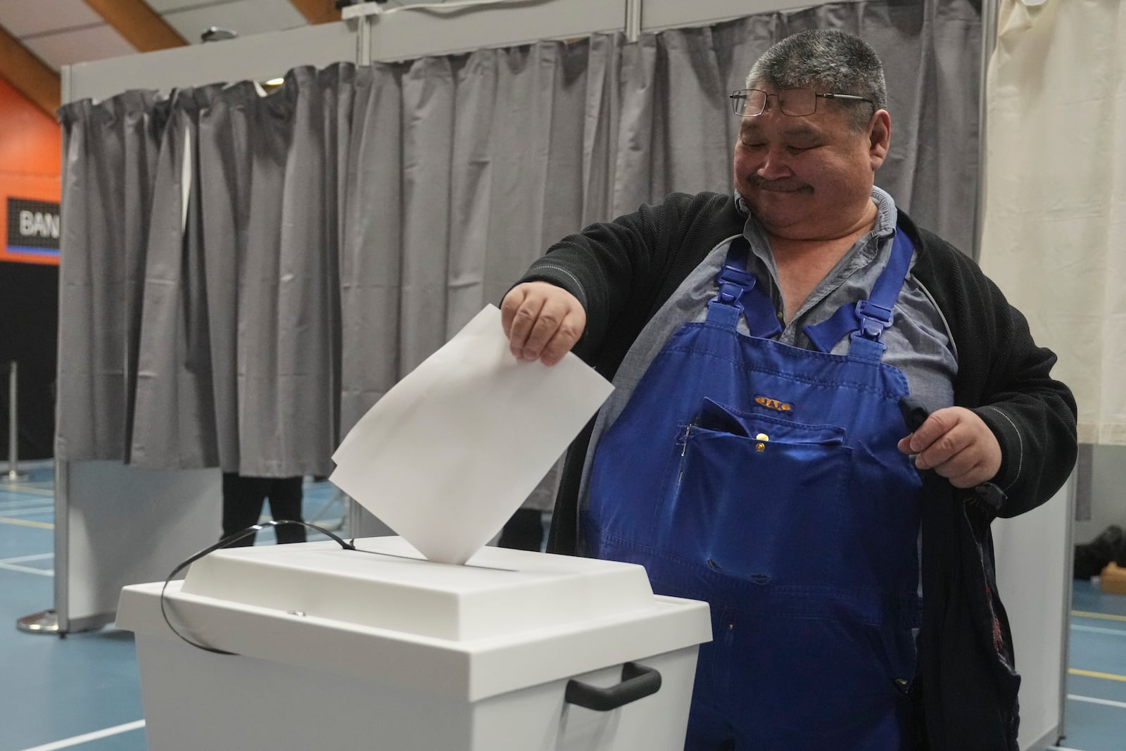 A man casts his vote in parliamentary elections, in Nuuk, Greenland, Tuesday, March 11, 2025. (AP Photo/Evgeniy Maloletka)