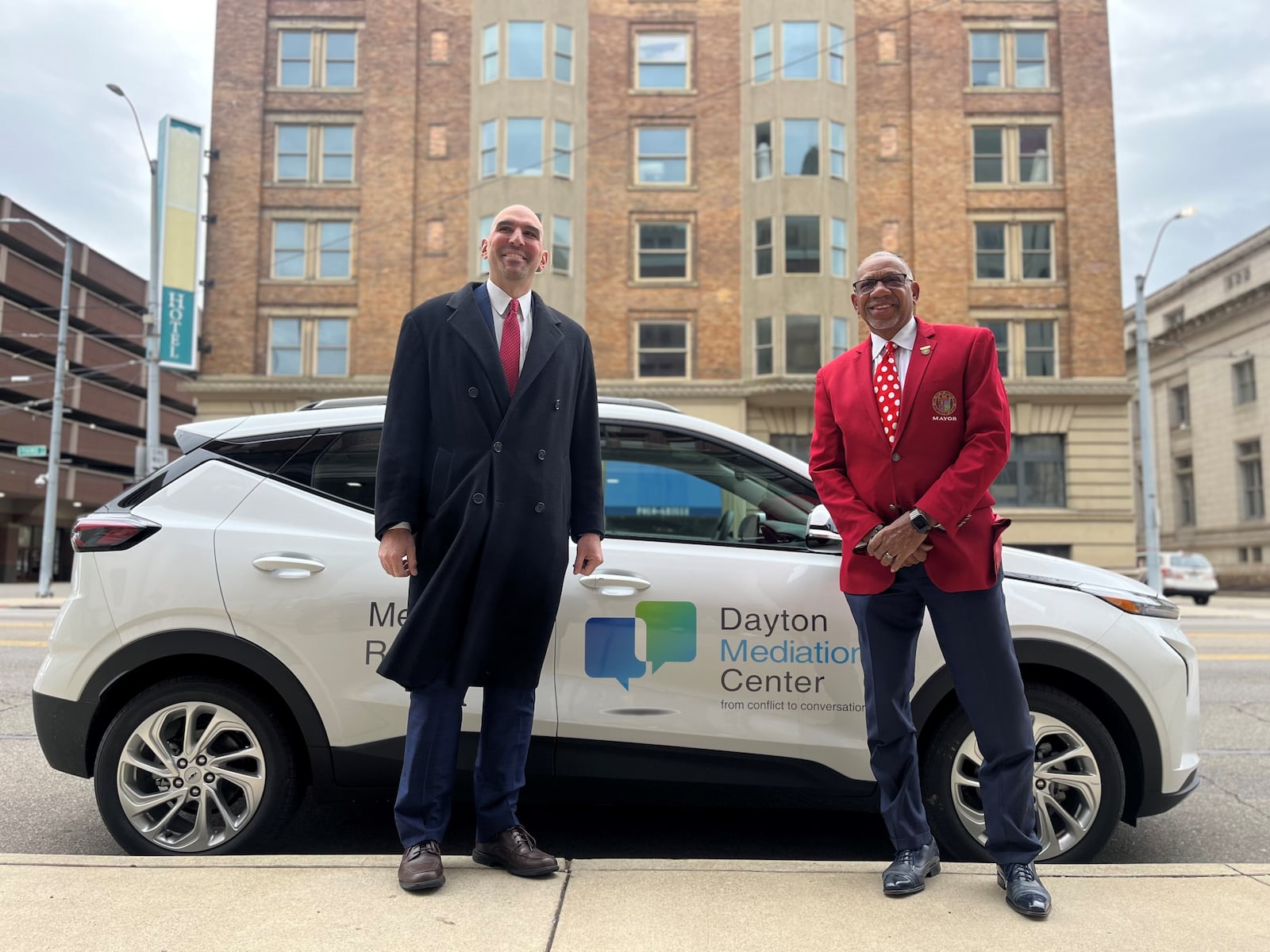 Dayton City Commissioner Matt Joseph and Mayor Jeffrey Mims Jr. show off one of the city's new all electric vehicles outside of City Hall on Friday, Dec. 2, 2022. CORNELIUS FROLIK / STAFF