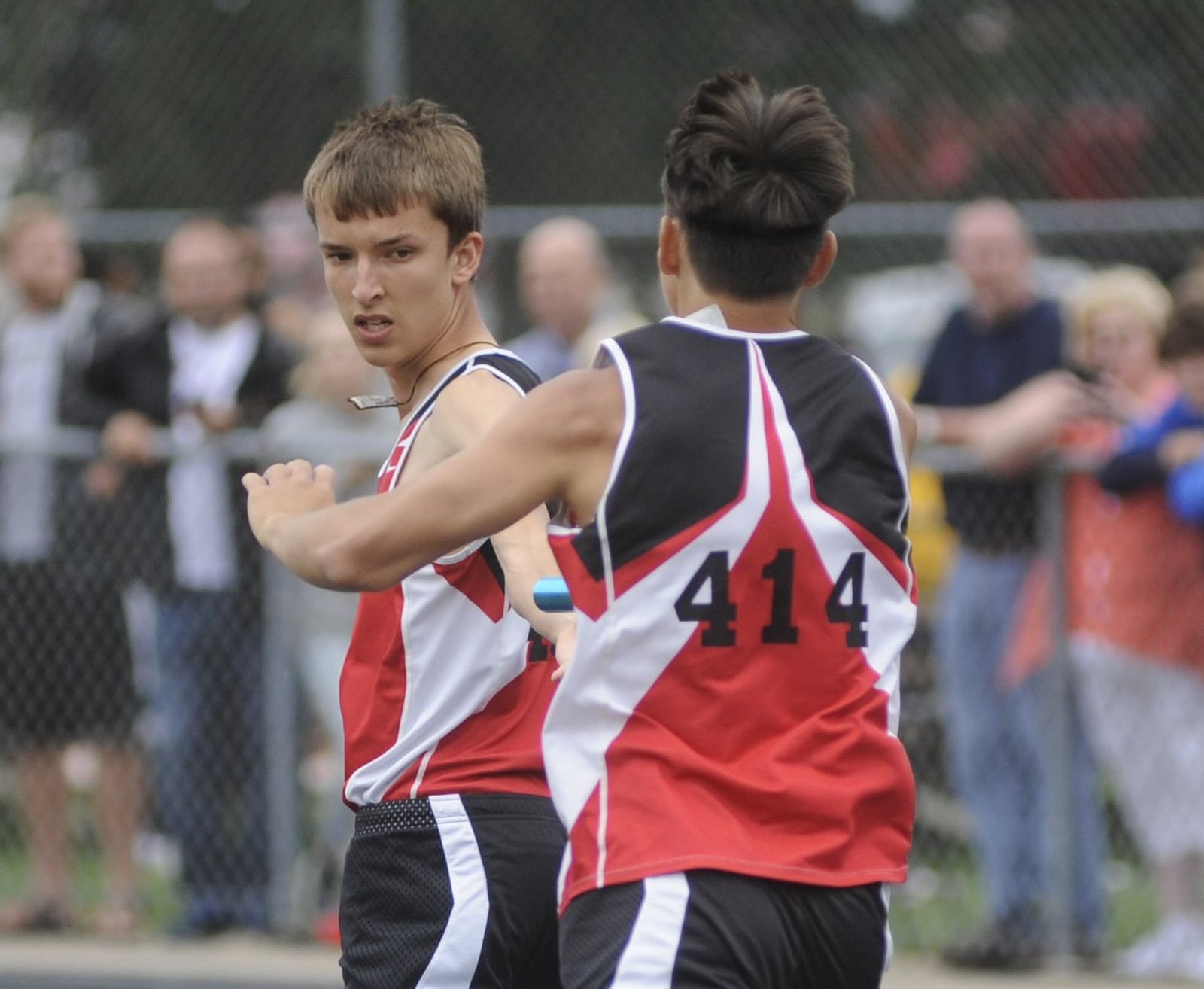 Alan Holdheide of Fort Loramie High School (right) passes the baton to Jake Rethman and the Redskins won the 4x800-meter relay during the D-III regional track and field meet at Troy’s Memorial Stadium on Wednesday, May 24, 2017. MARC PENDLETON / STAFF