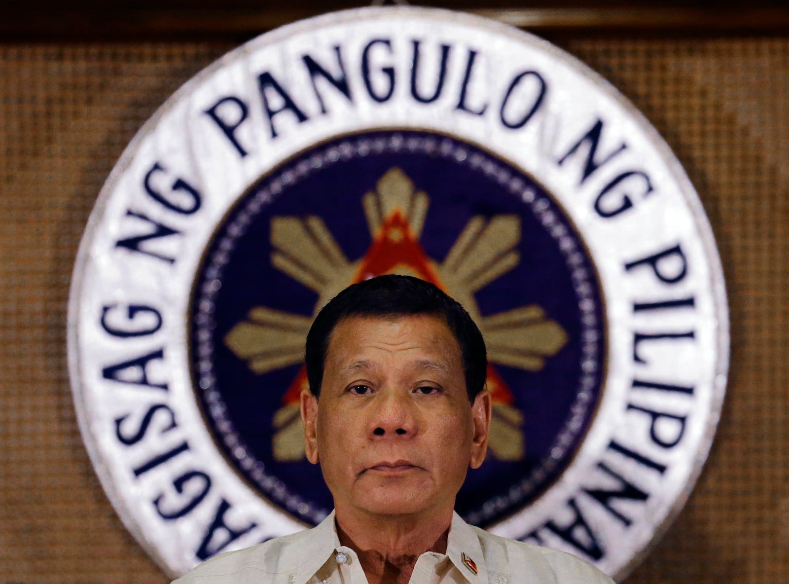 FILE - Philippine President Rodrigo Duterte stands in front of the presidential seal during a ceremony with the Armed Forces of the Philippines at the Malacanang presidential palace in Manila, Philippines on July 18, 2017. (AP Photo/Aaron Favila, File)