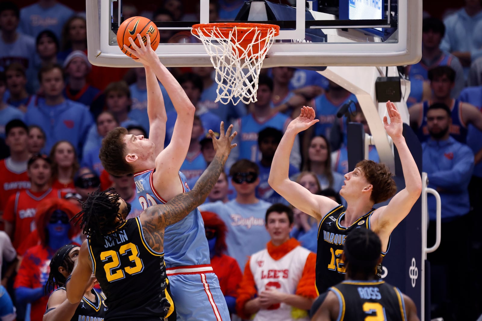 Dayton forward Amael L'Etang, second from left, looks to shoot in front of Marquette forward David Joplin (23), forward Ben Gold (12) and guard Chase Ross (2) during the first half of an NCAA college basketball game in Dayton, Ohio, Saturday, Dec. 14, 2024. (AP Photo/Paul Vernon)