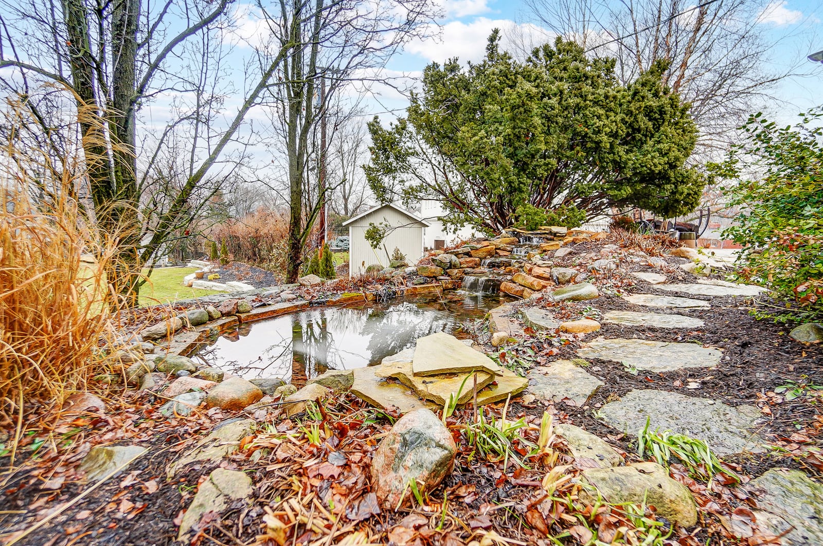 The rear of the home is heavily landscaped and has a pond and waterfall.