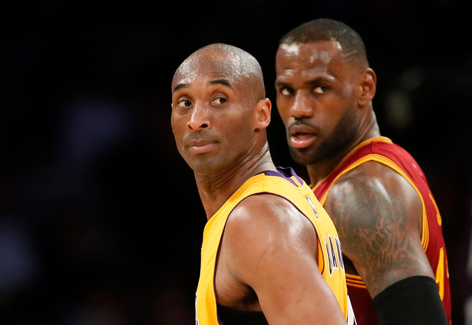 FILE - Los Angeles Lakers' Kobe Bryant, left, and Cleveland Cavaliers' LeBron James wait for play to resume during the first half of an NBA basketball game in Los Angeles, March 10, 2016. (AP Photo/Danny Moloshok, File)