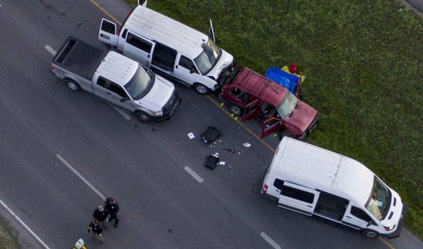 Officials investigate near a red vehicle believed to be that of the Austin bombing suspect Mark Conditt on I-35 in Round Rock on Wednesday