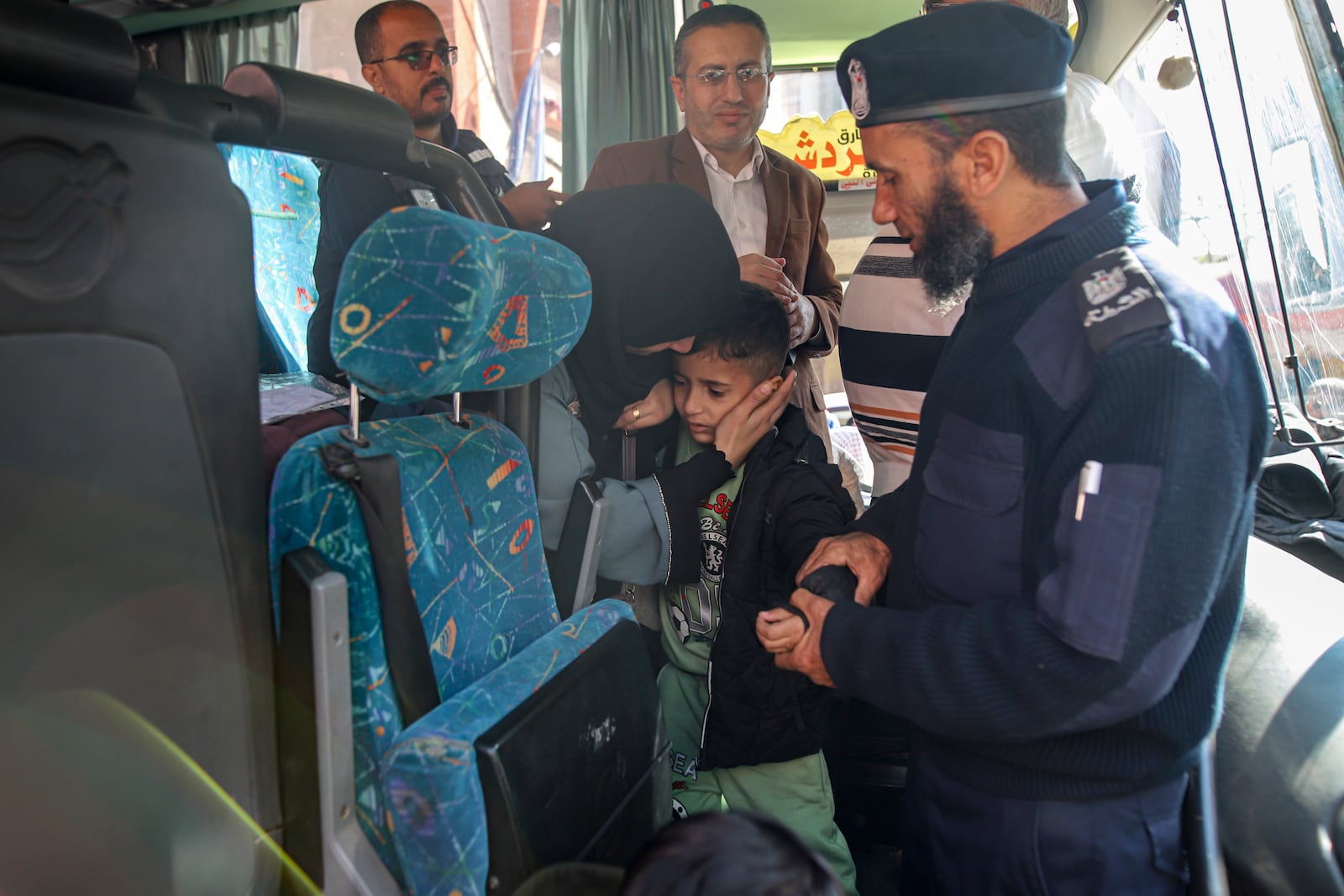 A boy is comforted before leaving to the Rafah crossing into Egypt, as wounded and sick Palestinians are allowed to leave the Gaza Strip for medical treatment, in Khan Younis, Saturday Feb. 1, 2025. (AP Photo/Jehad Alshrafi)