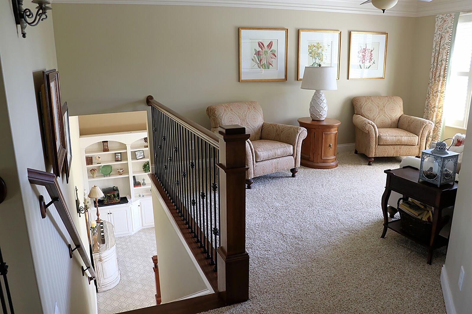 Tucked off the great room, the semi-open staircase leads to a loft family room. The room has a picture window, ceiling fan and accented by the wrought-iron spindle railing, which extends across the catwalk over the foyer toward 2 bedrooms and 2 full bathrooms. CONTRIBUTED PHOTO BY KATHY TYLER