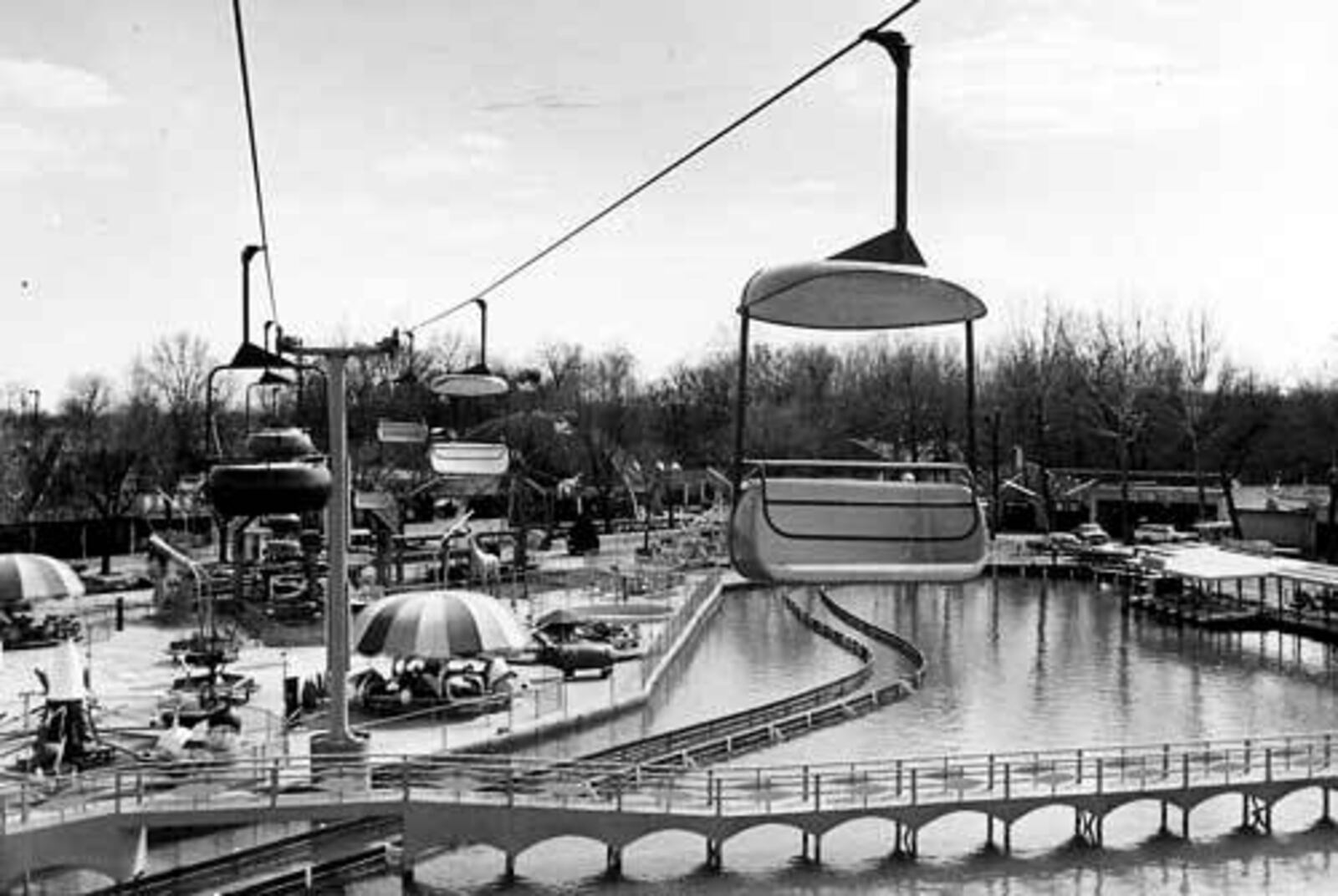 Sky Rider swings over the lake at Americana Amusement Park, formerly Lesourdsville Lake Amusement Park. (1969)