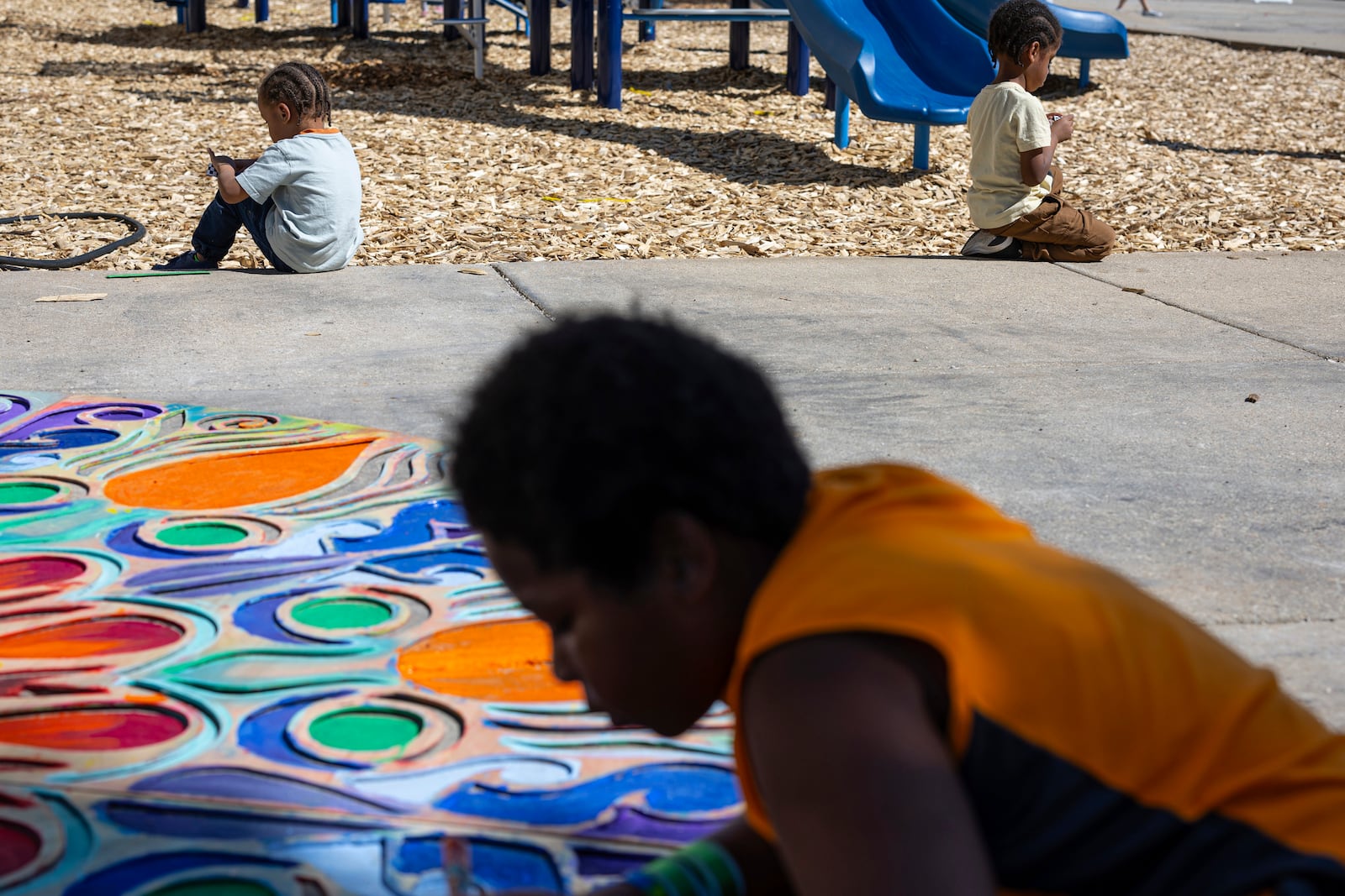 FILE - A child helps paint a display on the ground at a back to school health fair in Milwaukee, Aug. 10, 2024. (AP Photo/Jeffrey Phelps, File)